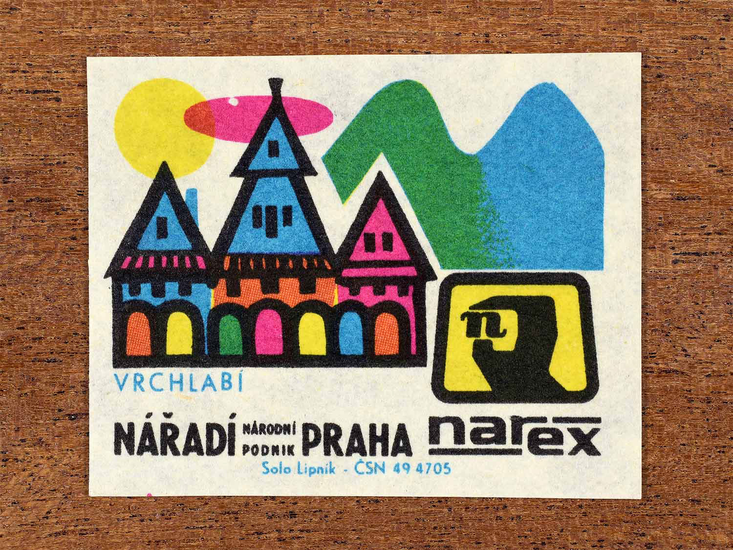 Vintage 1967 Czech matchbox label showing mountain town houses with alpine backdrop in multiple bright colours. Produced by the Solo Lipník match factory to promote Vrchlabí and Narex, the national tool enterprise in Czechoslovakia.
