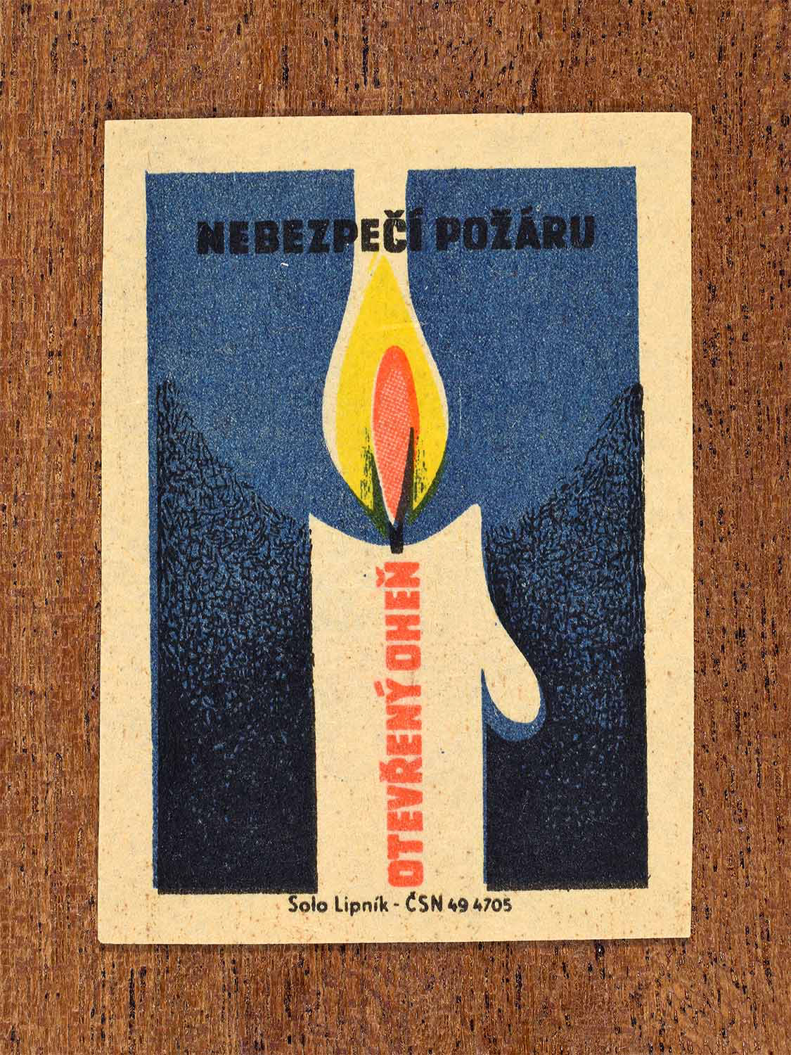 Vintage 1964 Czech matchbox label showing a burning candle against a blue background. Produced by the Solo Lipník match factory to warn about the danger of open flames.