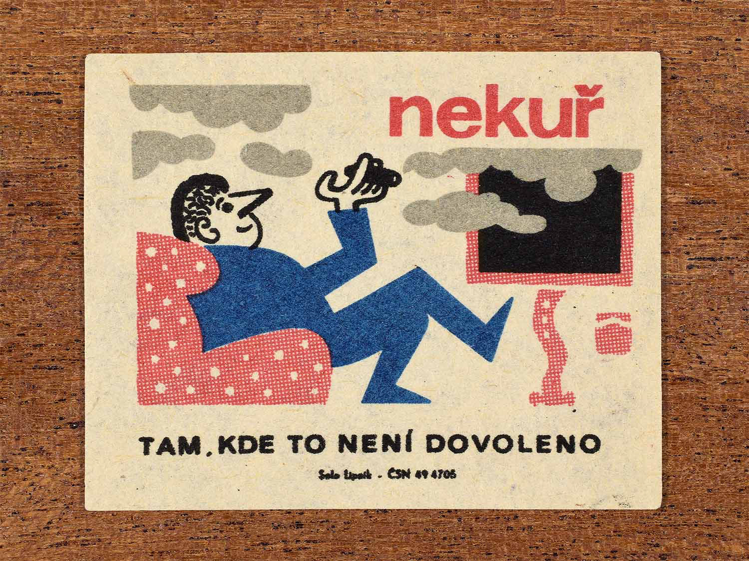Vintage c. 1964 Czech matchbox label showing a passenger smoking in a prohibited area, illustrated in blue, red and black. Produced by the Solo Lipník match factory to enforce no-smoking rules on trains.