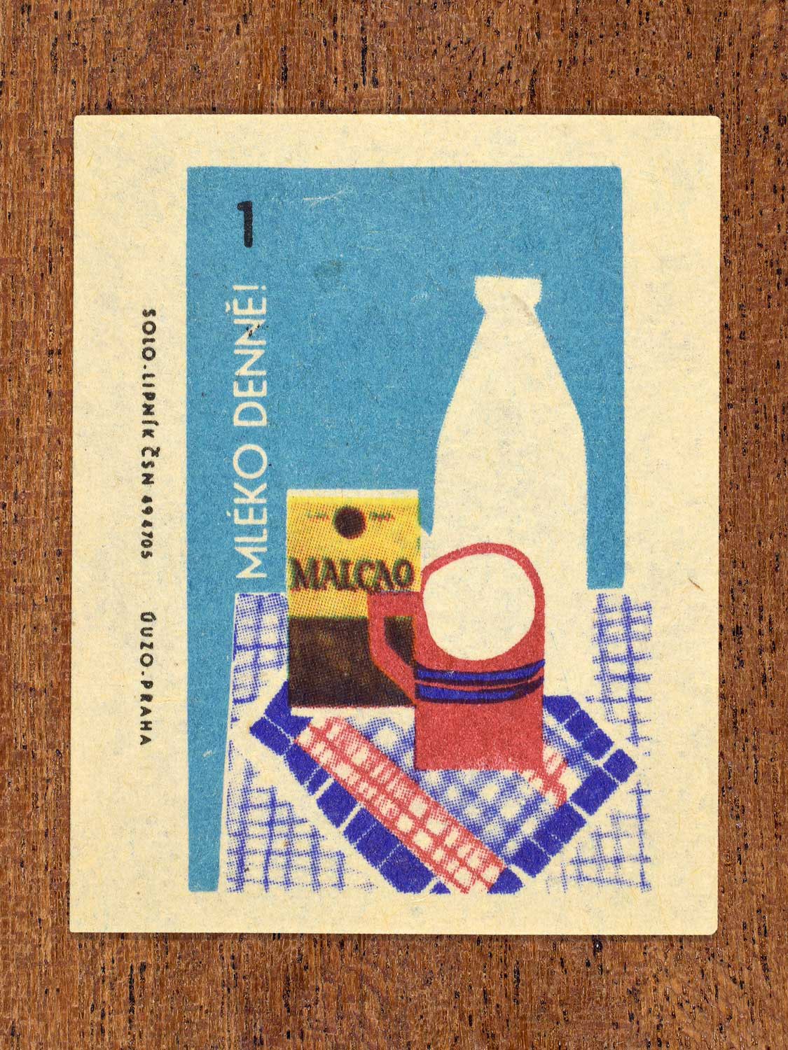 Vintage c. 1965 Czech matchbox label showing a milk bottle, mug, and package arranged on a tablecloth. Produced by Solo Lipník match factory to promote the health benefits proper nutrition, daily meal routines, and everyday household habits.