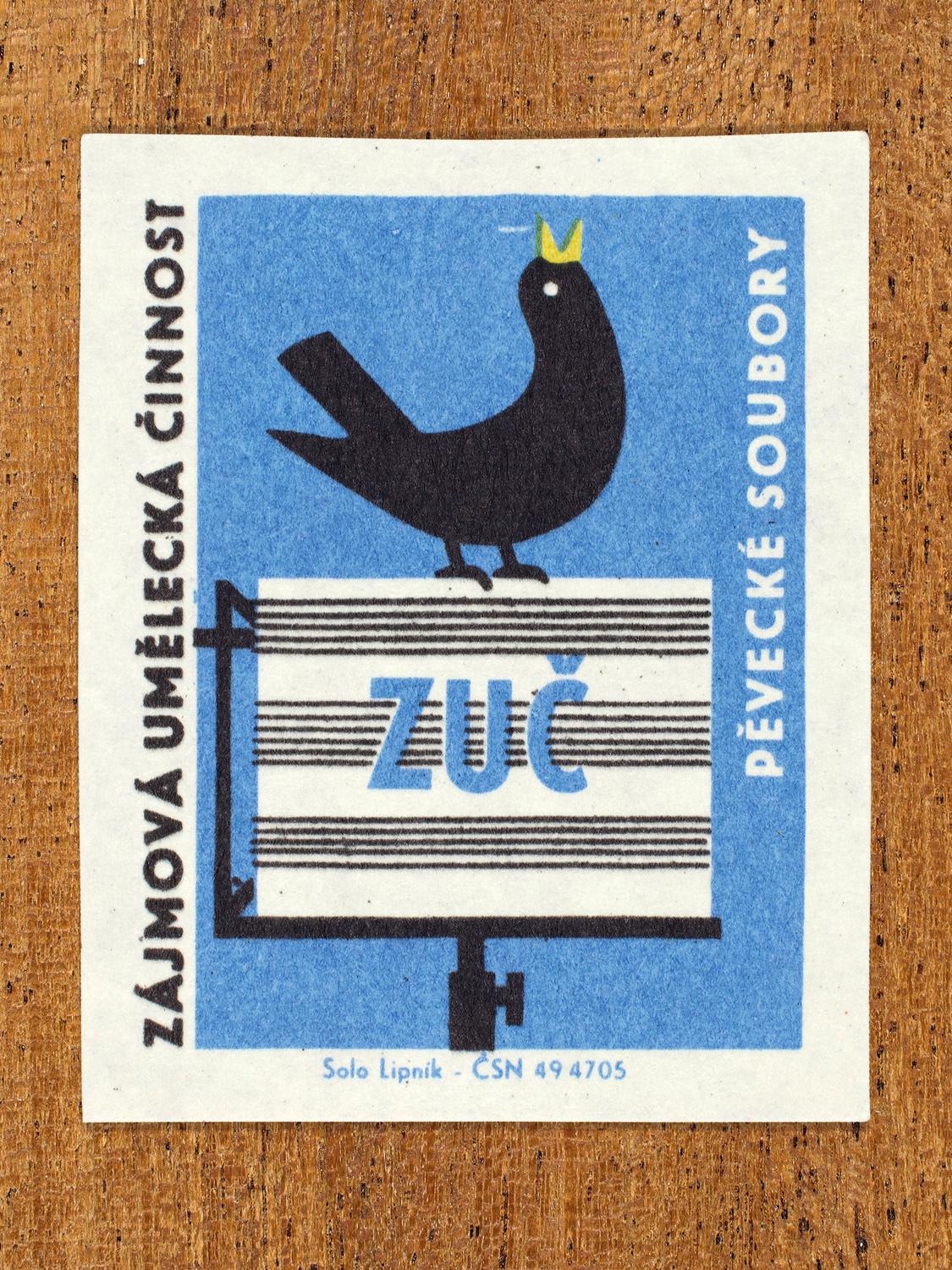 Vintage 1969 Czech matchbox label showing a stylised singing bird standing on top of a music stand, in blue, yellow and black colours. Produced by the Solo Lipník match factory to promote state-organised art groups in Czechoslovakia.