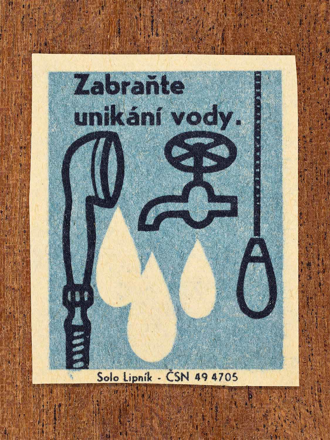 Vintage 1966 Czech matchbox label showing a leaking tap and shower head with large falling water drops in blue and black colours. Produced by the Solo Lipník match factory to promote preventing water leakage and waste.