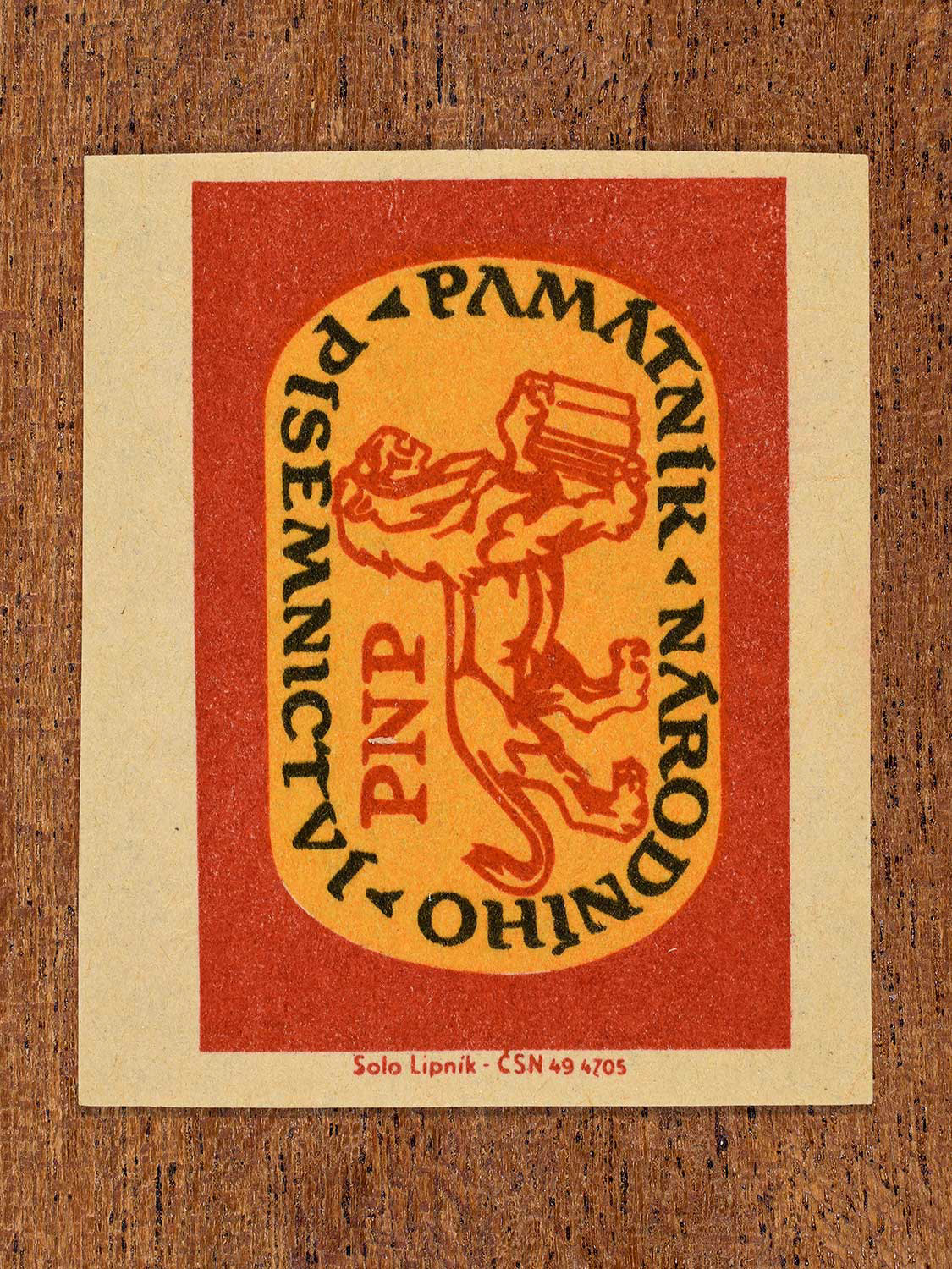 Vintage 1964 Czechoslovakia matchbox label showing an emblem design featuring lion holding a book in yellow and red colours. Produced by the Solo Lipník match factory to promote the Památník Národního Písemnictví – PNP (Museum of National Literature) in Czechoslovakia.