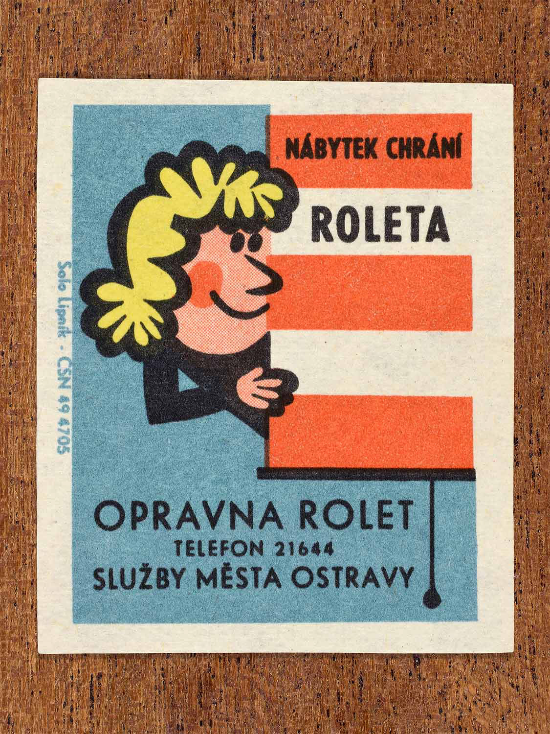 Vintage 1967 Czech matchbox label showing a cartoon woman beside striped window blinds. Produced by the Solo Lipník match factory to promote municipal blind repair services.