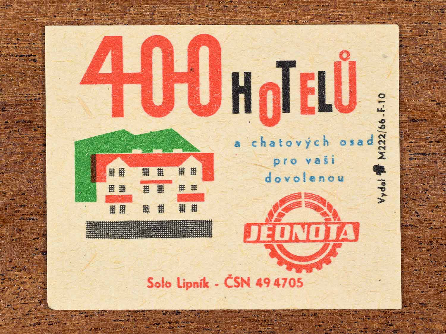 Vintage c. 1966 Czech matchbox label showing a stylised hotel building with bold red and green geometric shapes. Produced by the Solo Lipník match factory to advertise Jednota cooperative hotels and holiday cottages.