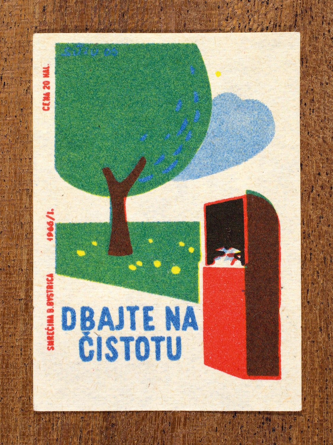 Vintage 1966 Czech matchbox label by Solo Smrečina B. Bystrica featuring a tree and a waste bin in a public park. It encourages people to keep their surroundings clean and free of litter.