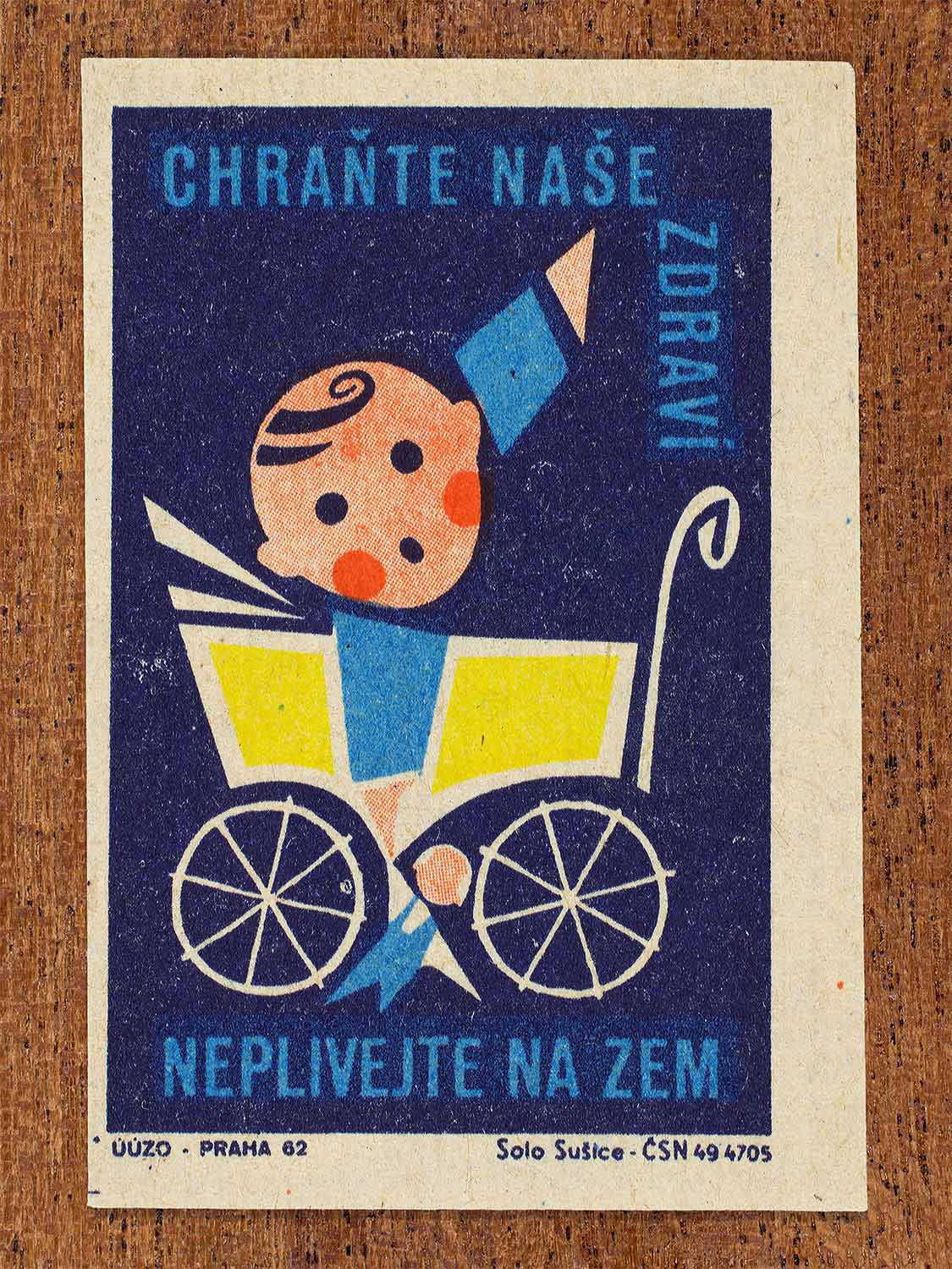 Vintage 1962 Czech matchbox label by Solo Sušice featuring a baby in a pram pointing upwards. Part of the 'Protect Health' series urging citizens not to spread germs through spitting, and to protect the health of children.