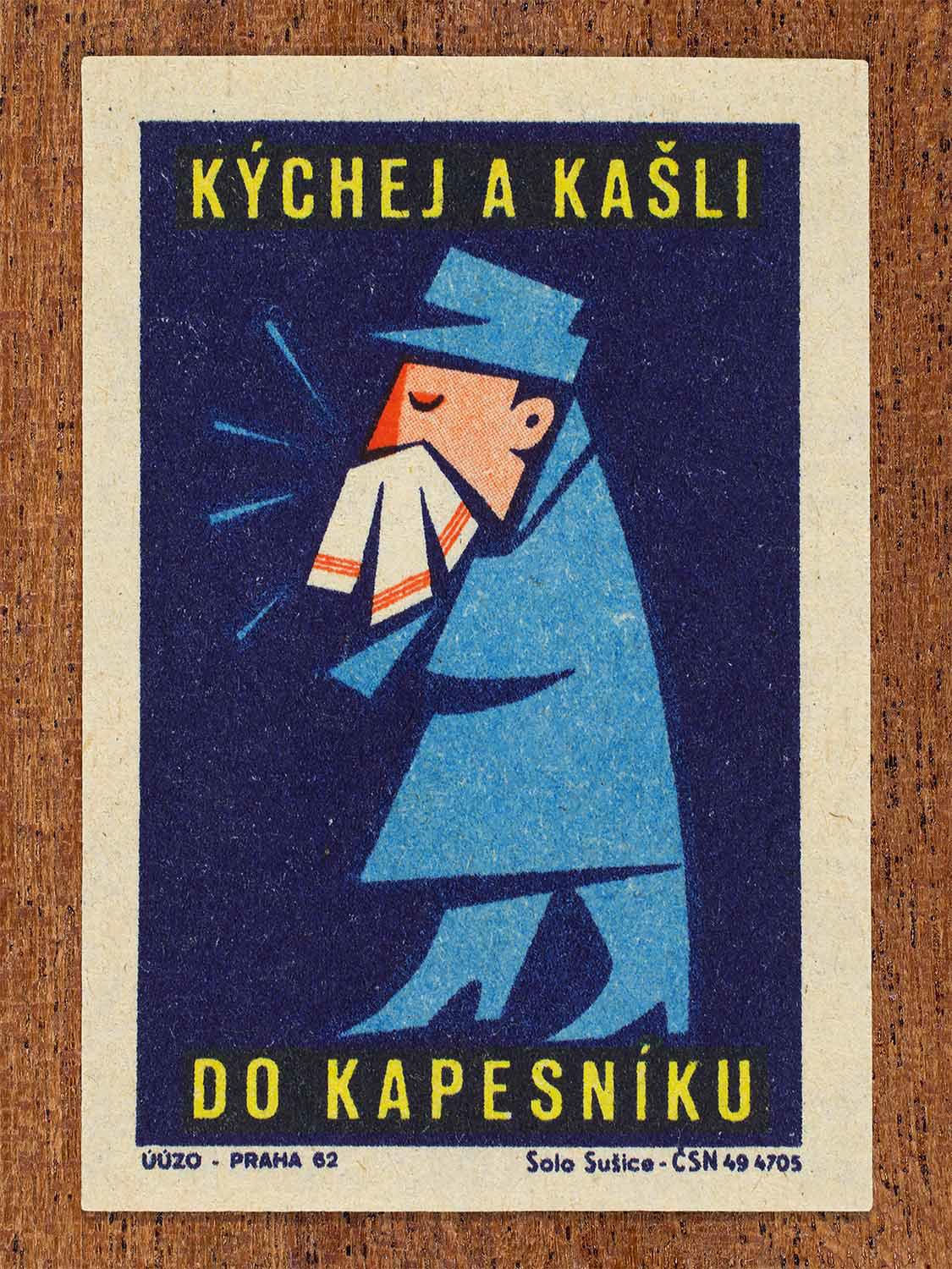 Vintage 1962 Czech matchbox label by Solo Sušice featuring a stylized person sneezing into a handkerchief. Part of the 'Protect Health' series This public-awareness design promotes exercising good manners and preventing the spread of infection.