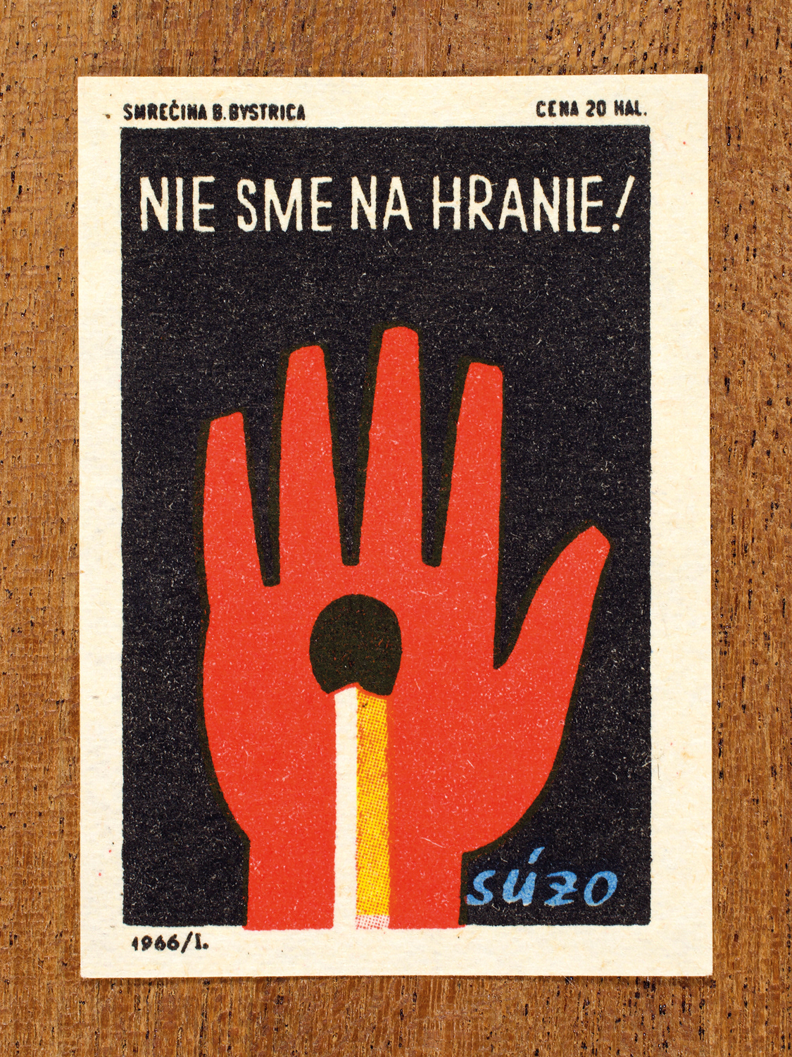 Vintage 1966 Czech matchbox label by Solo Smrečina B. Bystrica featuring a red stylised hand raised against a dark background, with a match-stick motif on the palm. It warns against the careless or playful use of matches to prevent burns and fires.
