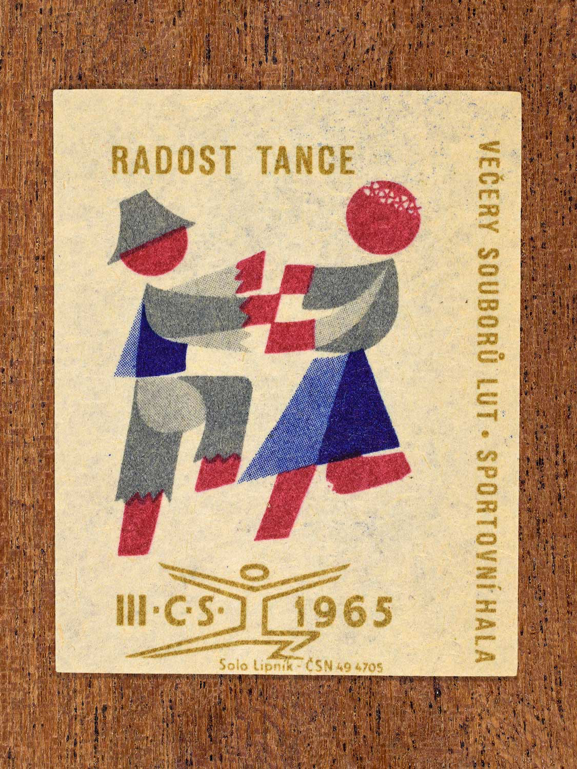 Vintage 1965 Czechoslovak matchbox label showing two stylised folk dancers in blue, red and gold colours. Produced by the Solo Lipník match factory to promote joyful social dance.