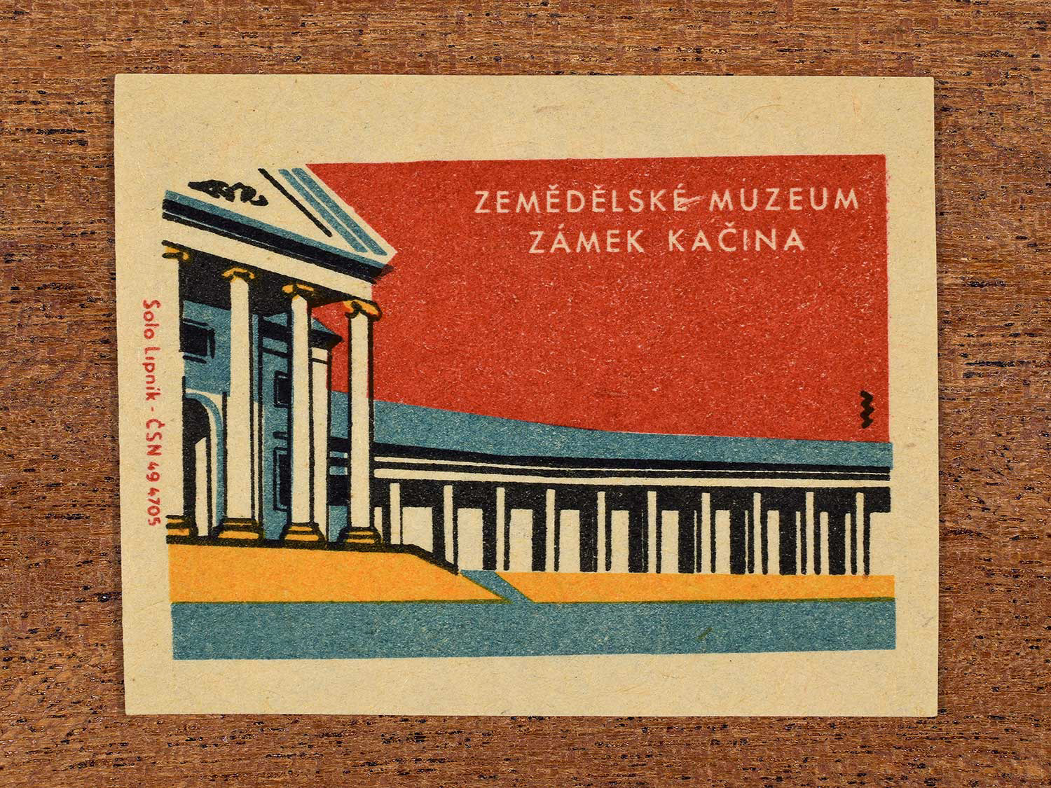 Vintage 1964 Czechoslovakia matchbox label showing the Zemědělské Muzeum Zámek Kačina (National Museum of Agriculture, Kačina) in yellow, red and teal colours. Produced by the Solo Lipník match factory to promote domestic historical heritage and municipal institutions across the state.