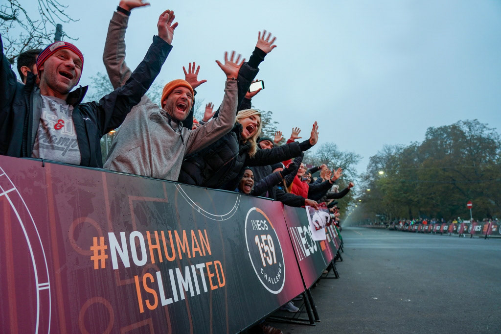Supporters get ready in the pre-dawn light near the finish line to welcome Eliud Kipchoge and his pacemaking team at the Fan Zone Kaiserallee. The INEOS 1:59 Challenge. 12 October 2019.
Photo: Jed Leicester for The INEOS 1:59 Challenge