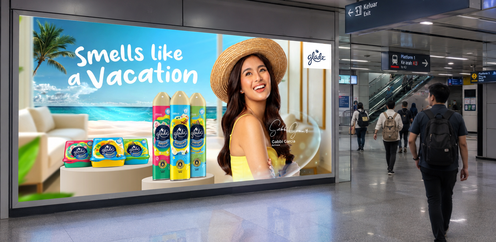 Glade "Smells Like a Vacation" campaign on a large-format backlit billboard inside a transit station, with commuters walking past escalators and platform signage. The ad shows Gabbi Garcia beside the Glade range against a beach scene. SC Johnson out-of-home air care campaign.