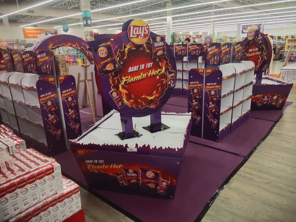 The activation built and deployed — the flame-ring archway, "Dare to Try" product walls, and the Limited Edition base treatment standing as the centrepiece of the retail floor.