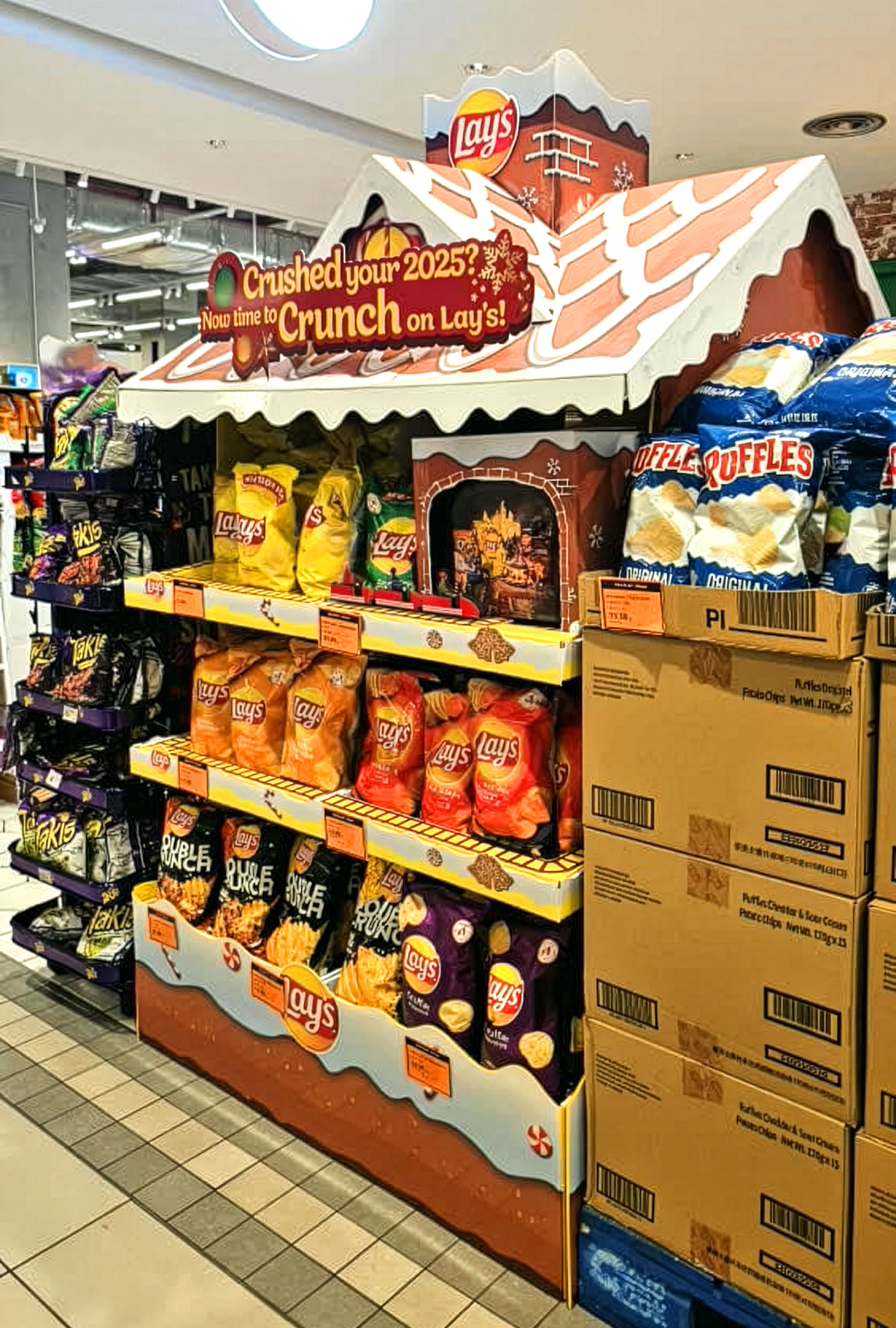 The display in context — in a working supermarket aisle, doing the festive job a flat shelf can't.