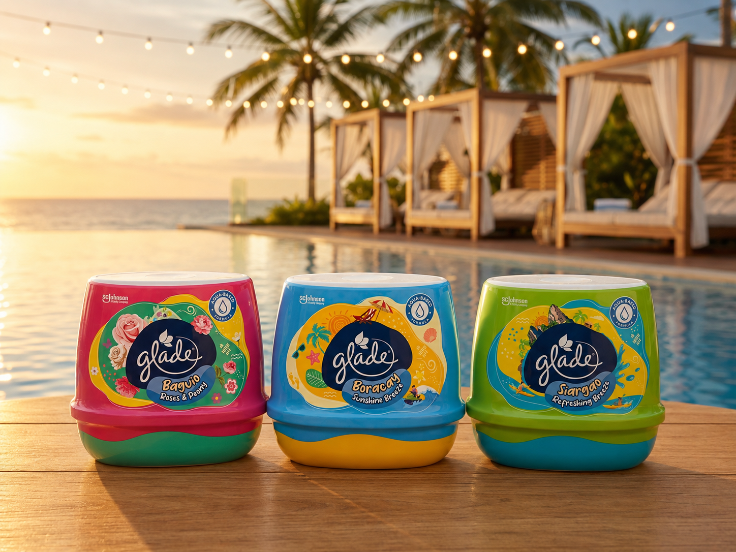 Three Glade "Spraycation" scented gel tubs — Baguio Roses & Peony (pink), Boracay Sunshine Breeze (blue) and Siargao Refreshing Breeze (green) — lined up on a wooden table beside a sunset infinity pool with palm trees and cabanas. SC Johnson air care packaging design, Philippines.