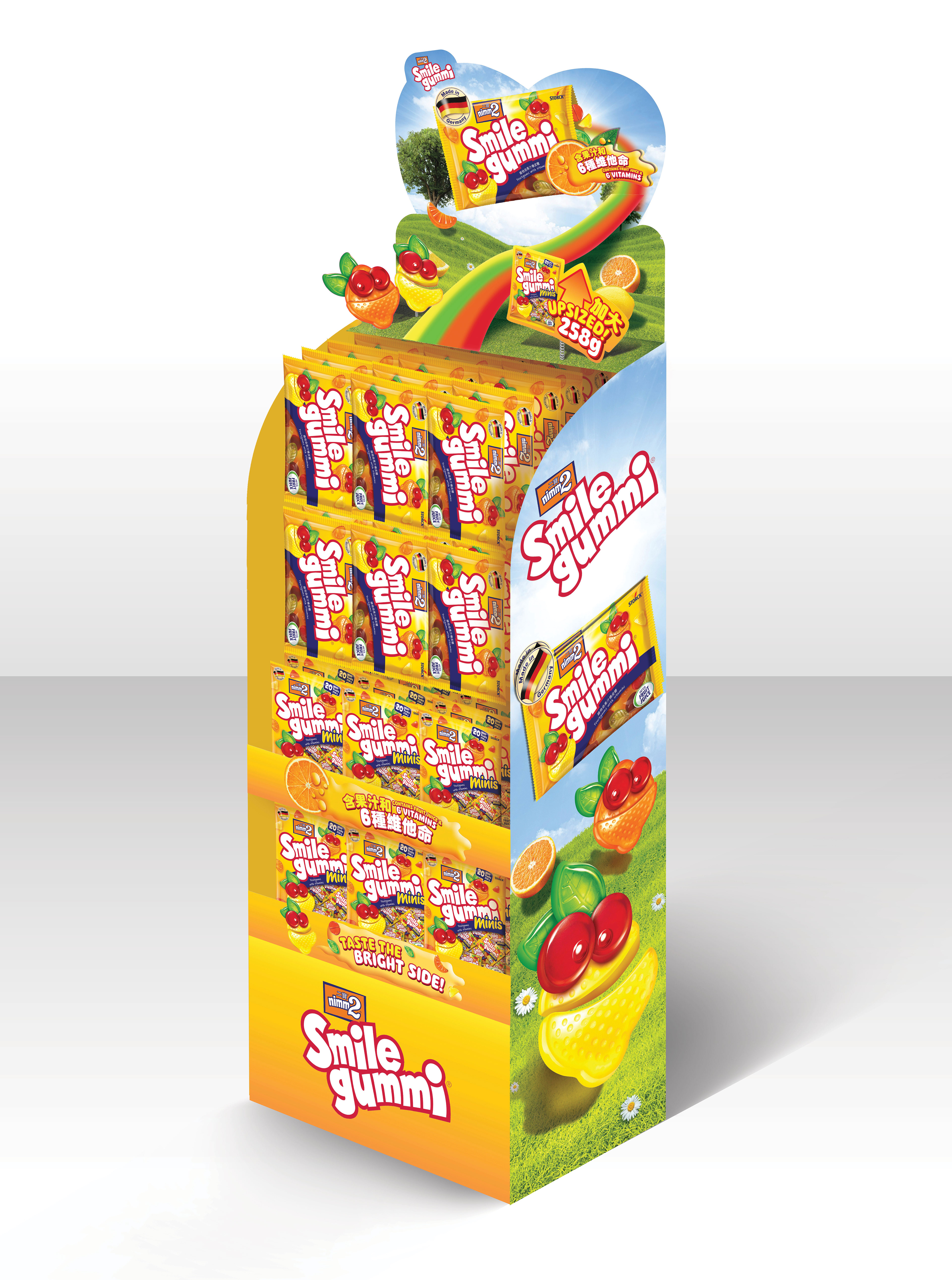 The finished standee in retail — heart-shaped printed topper, full Smile Gummi range across regular and Mini SKUs, Taste the Bright Side! anchored at the base.