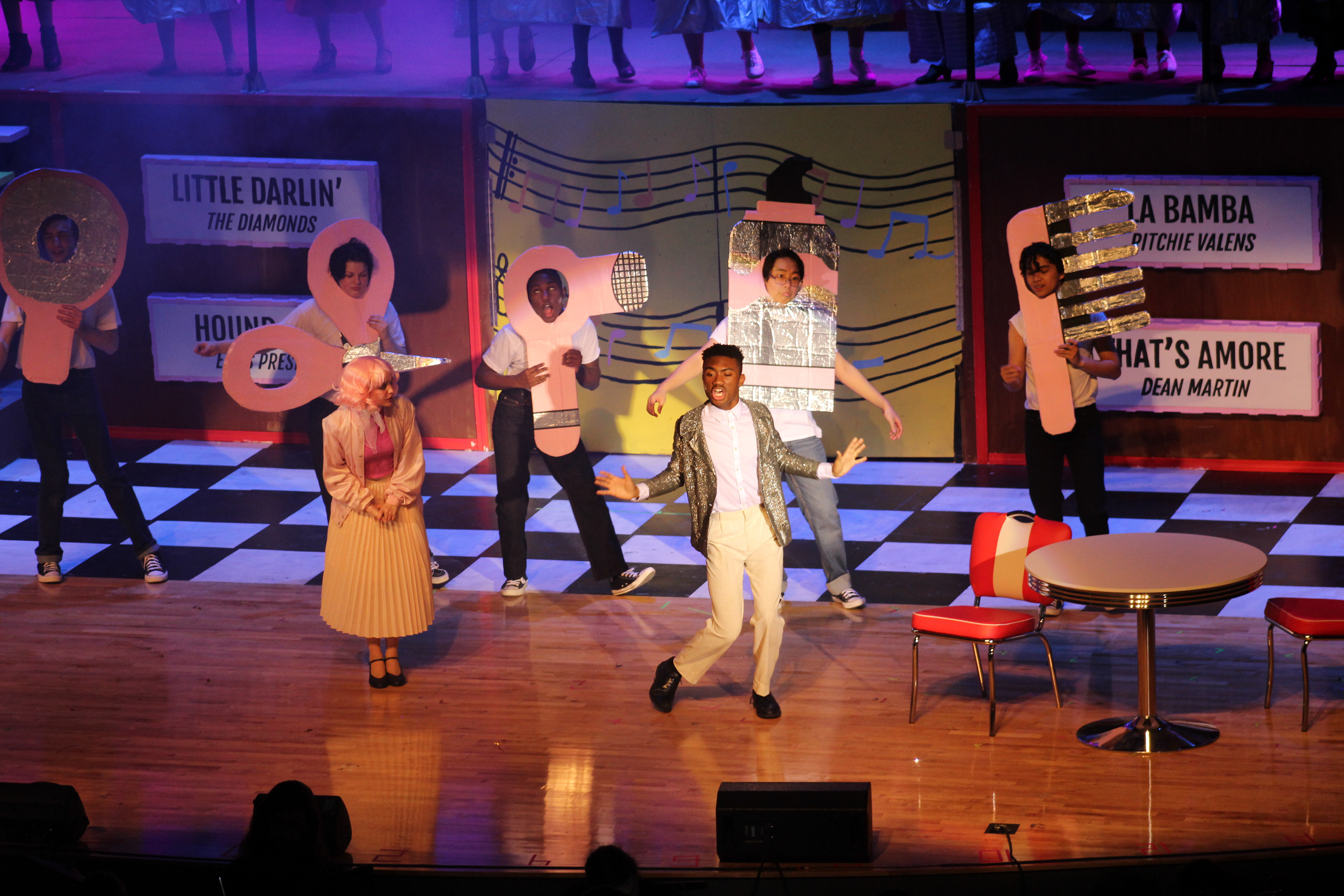 Ensemble members wear various beauty products during "Beauty School Dropout"