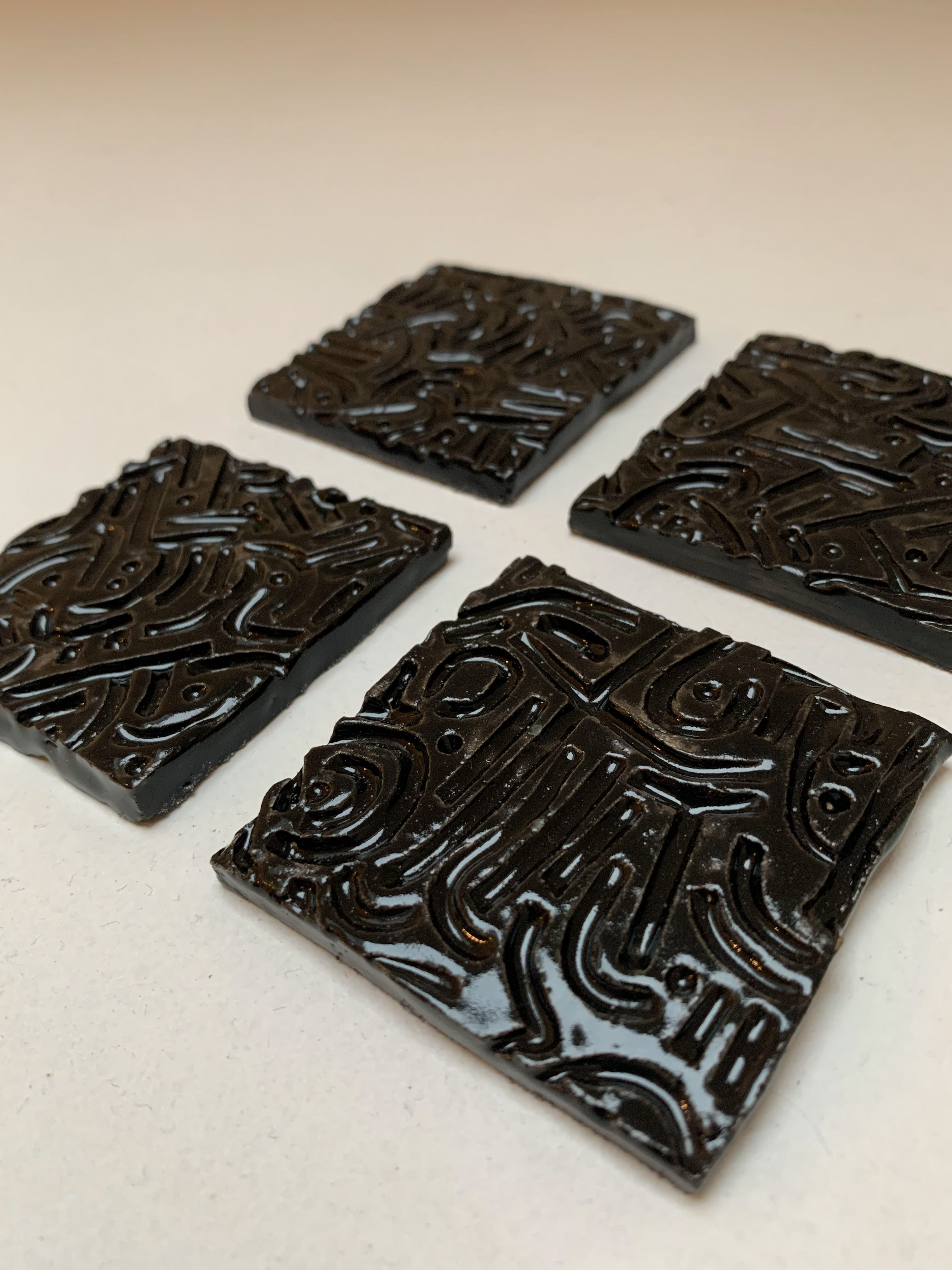 Four black miniature tiles