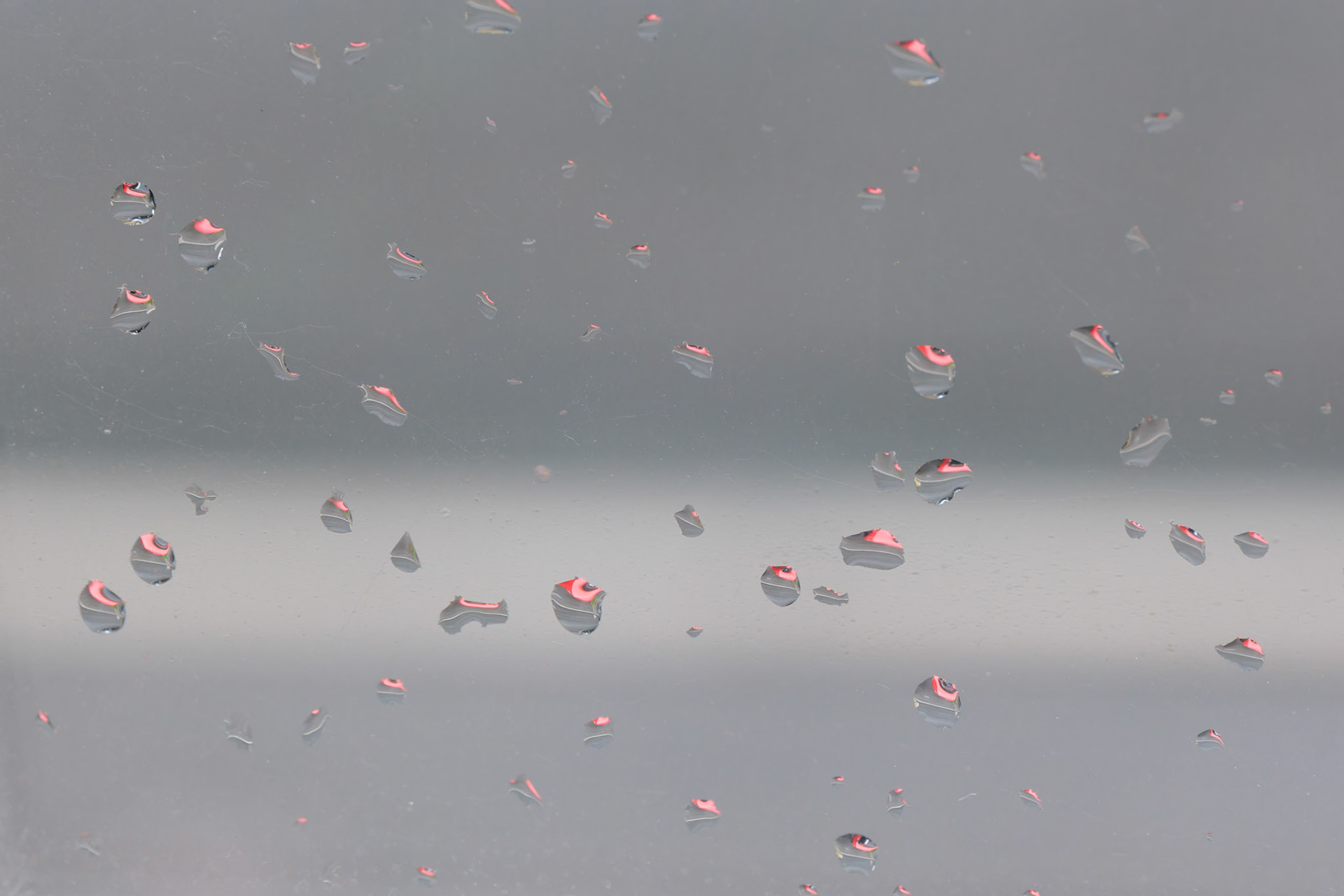 Red car reflected in raindrops