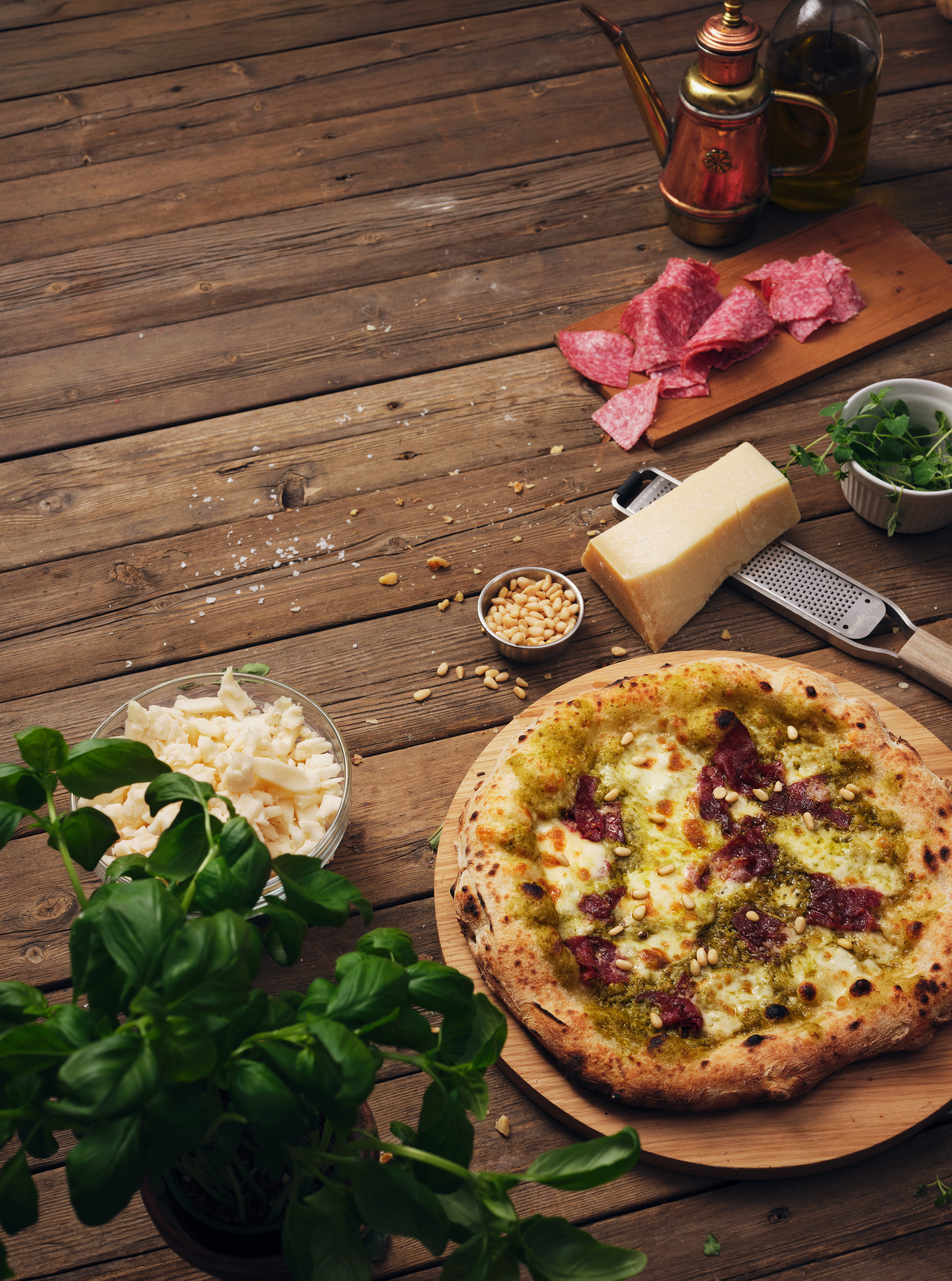 Reklambilder fotade i en studio. Pizza med olika ingredienser i en rustik miljö