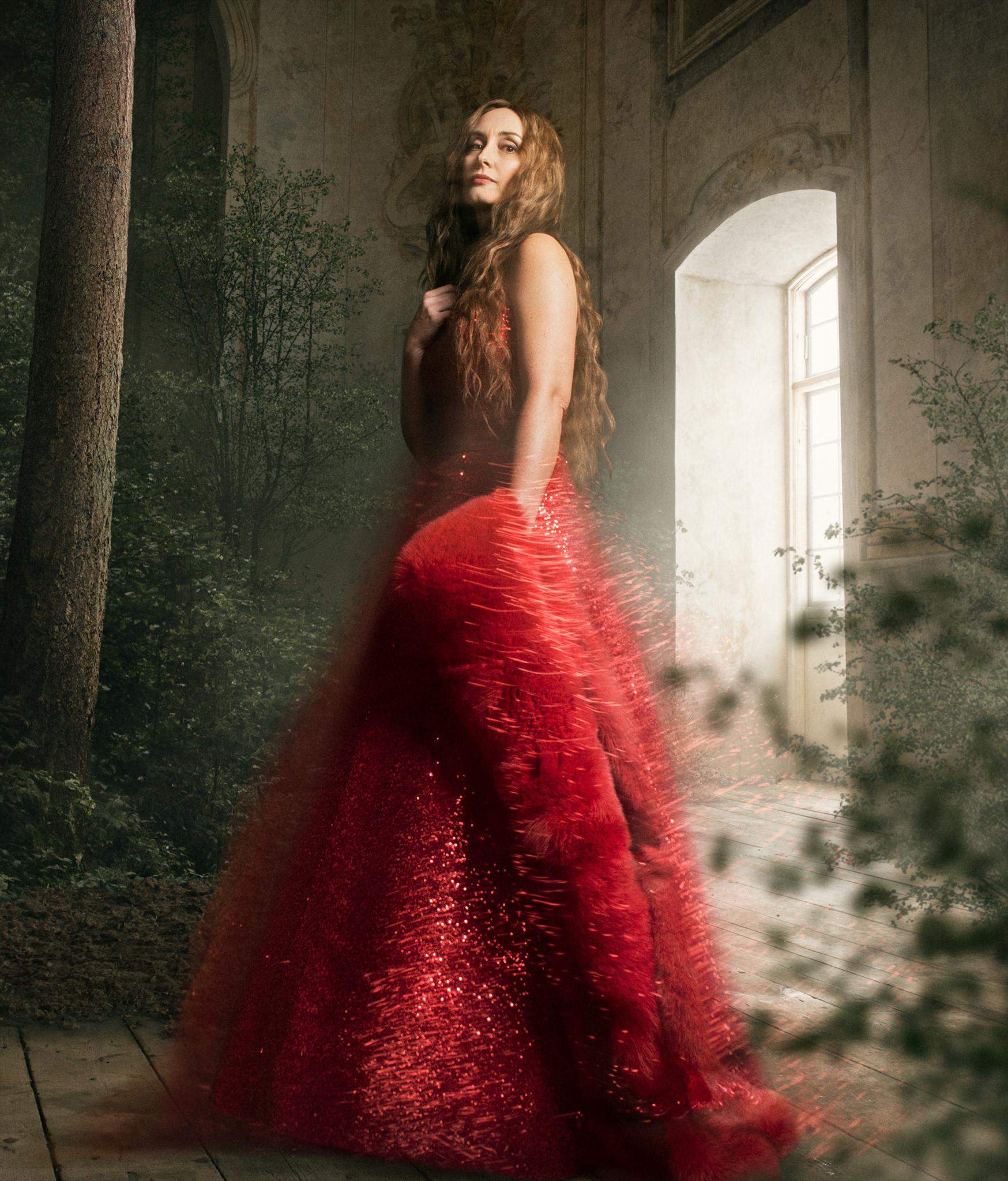 Fotomontage i en gammal byggnad med olika växter som, kvinnan har en svävande röd klänning på sig. Reklam för Kungliga operan