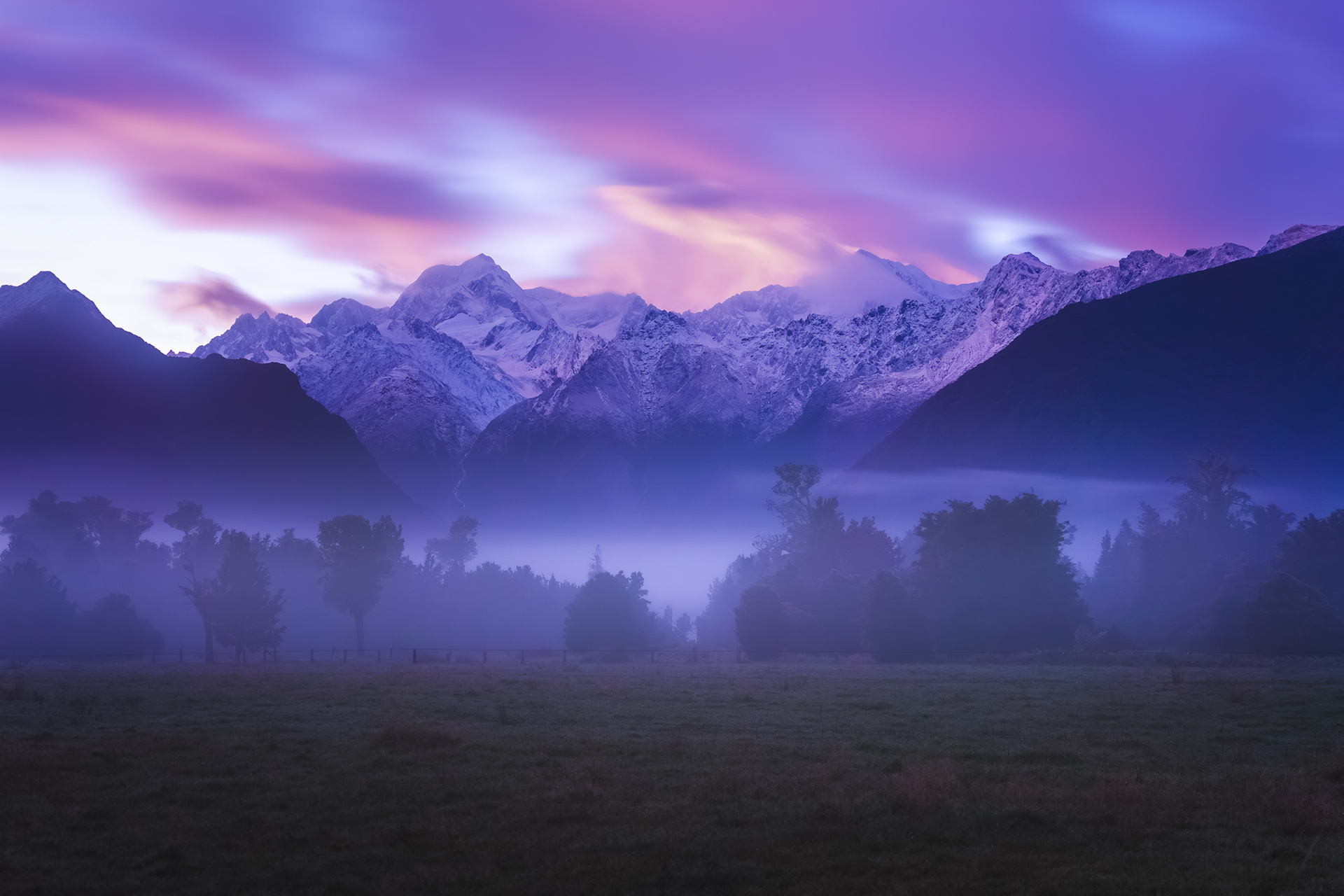 Westland Tai Poutini National Park at sunrise with Aoraki Mount Cook National Park rising into the clouds