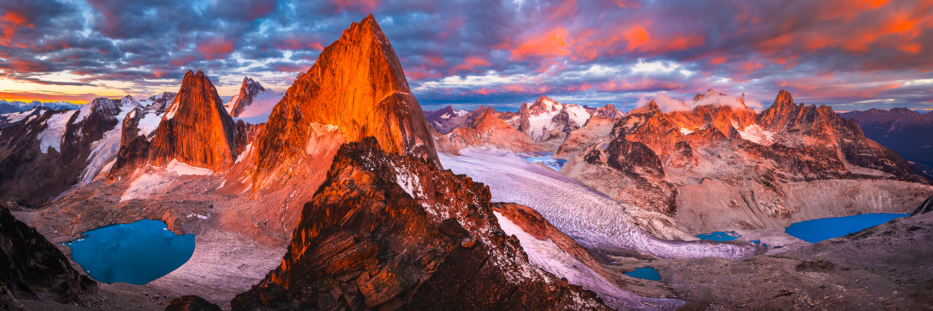 Sunrise from Crescent Spire in Canada’s Bugaboo Provincial Park. In the center is Bugaboo Spire with Snowpatch Spire to the left and Pigeon Spire behind and between them. On the right side is the huge Vowell Glacier and the smaller one on the left is Crescent Glacier.
