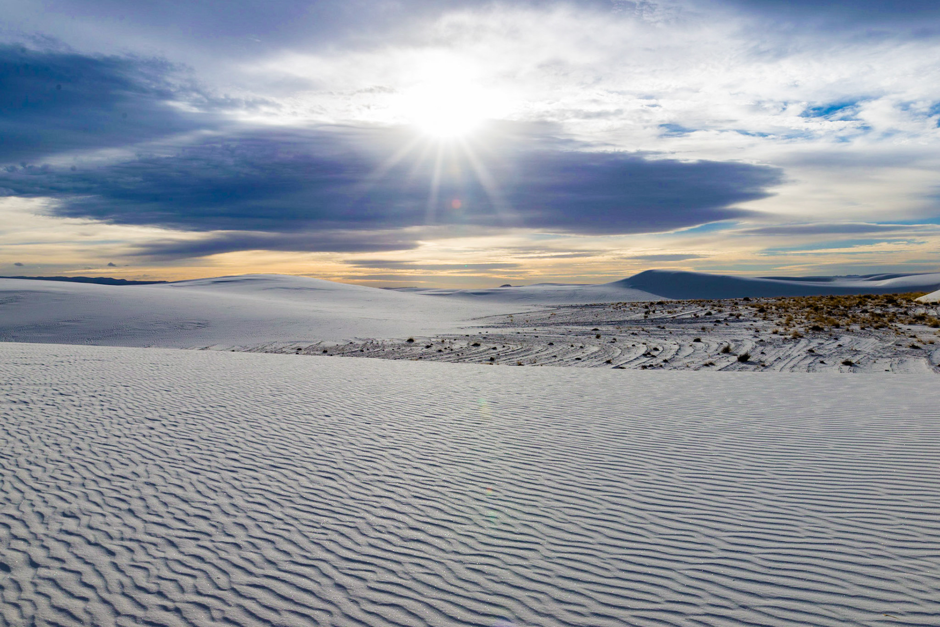 Sunrise over the White Sands National Monument casts stark shadows over the rivulets of sand atop the large sand dunes.