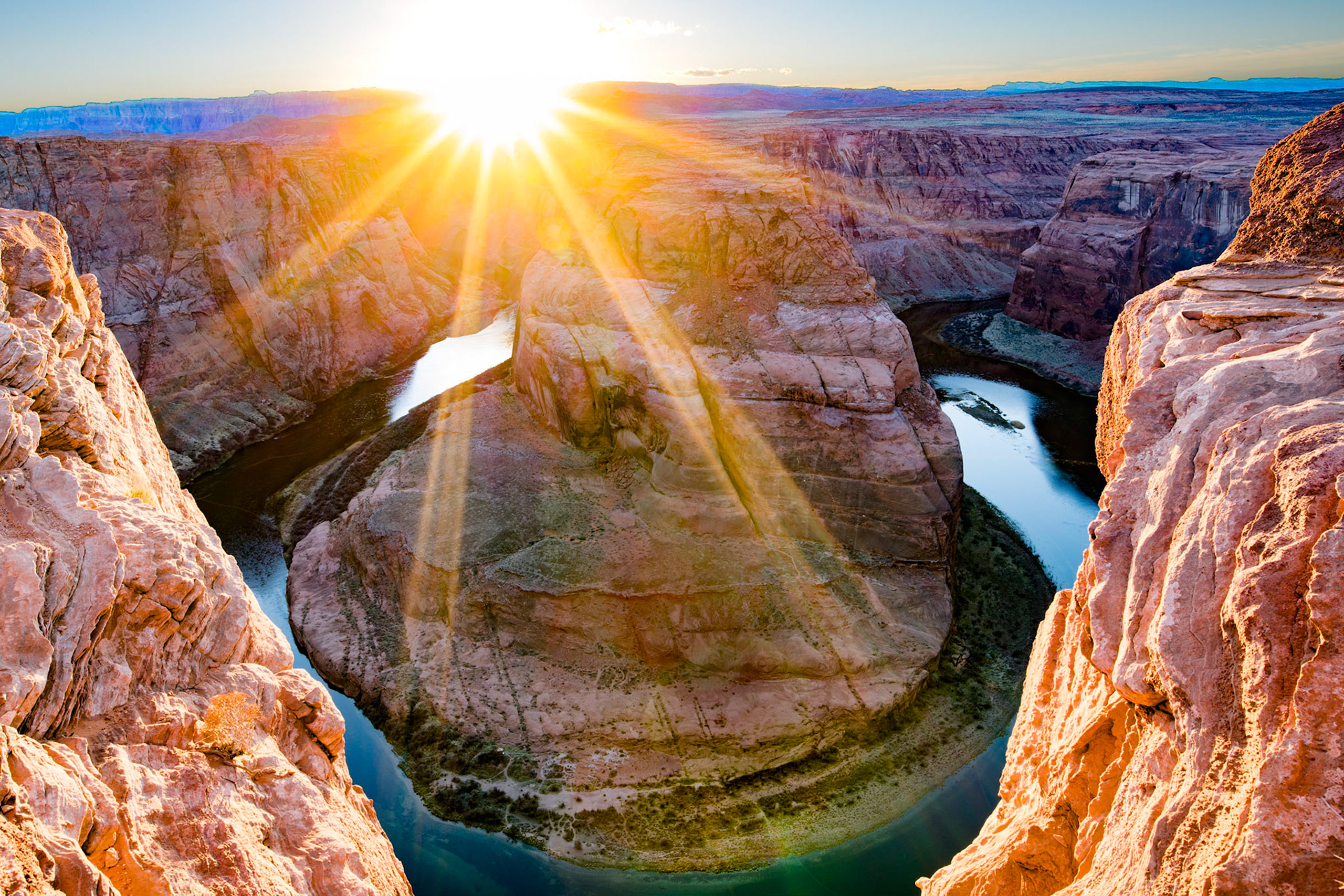 The setting sun behind the Horseshoe Bend of the Grand Canyon, in Page Arizona