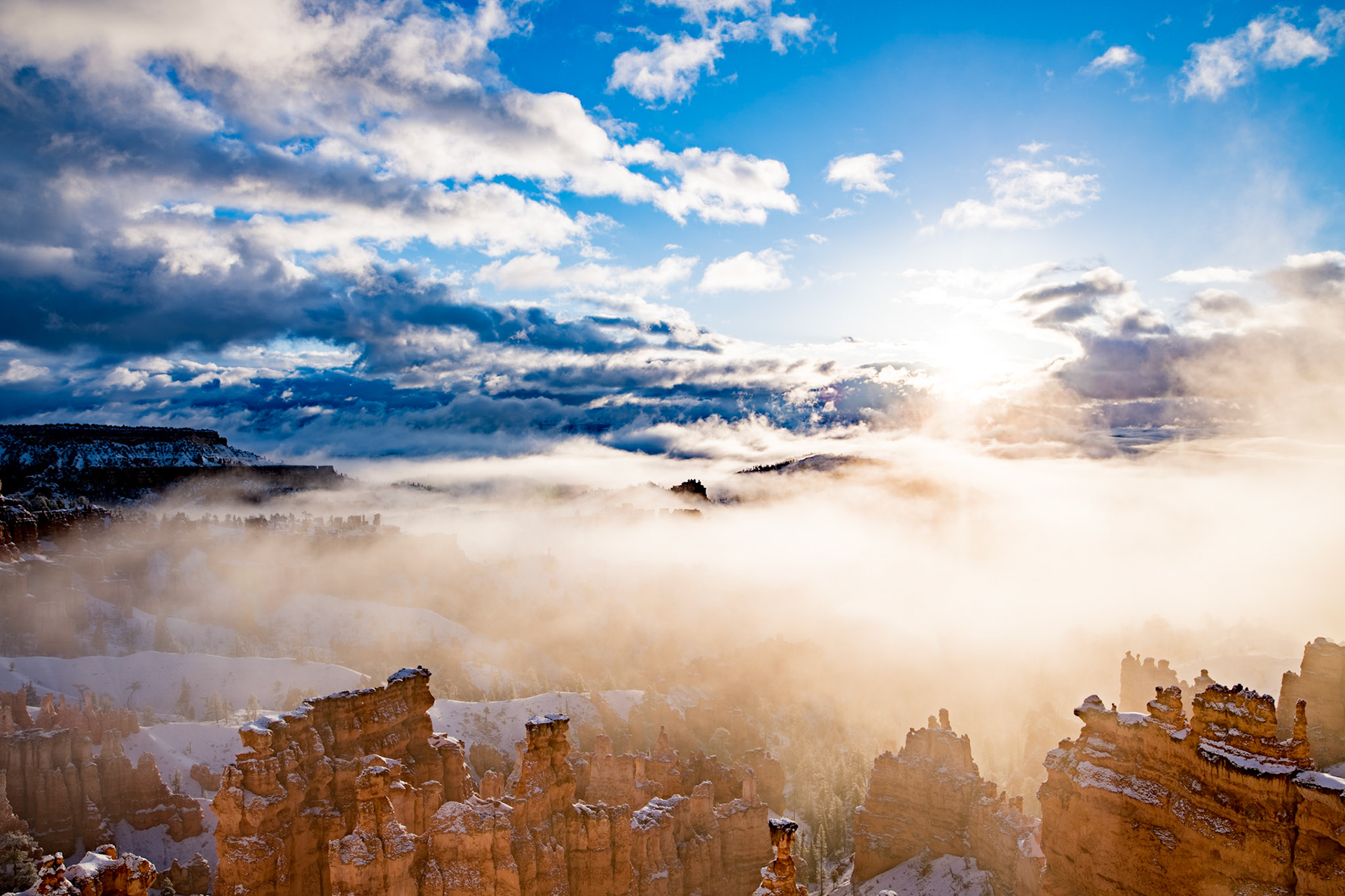 Early morning in Bryce Canyon, the new snowfall sat undisturbed and unseen until we showed up at 6:50am.  The overcast clouds were hiding the wonder and amazement that would be forthcoming 30 minutes after sunrise.  Slowly but surely the sun burned its way through the upper cloud layer only to explode on this amazing vista and astonish all that witnessed the event.