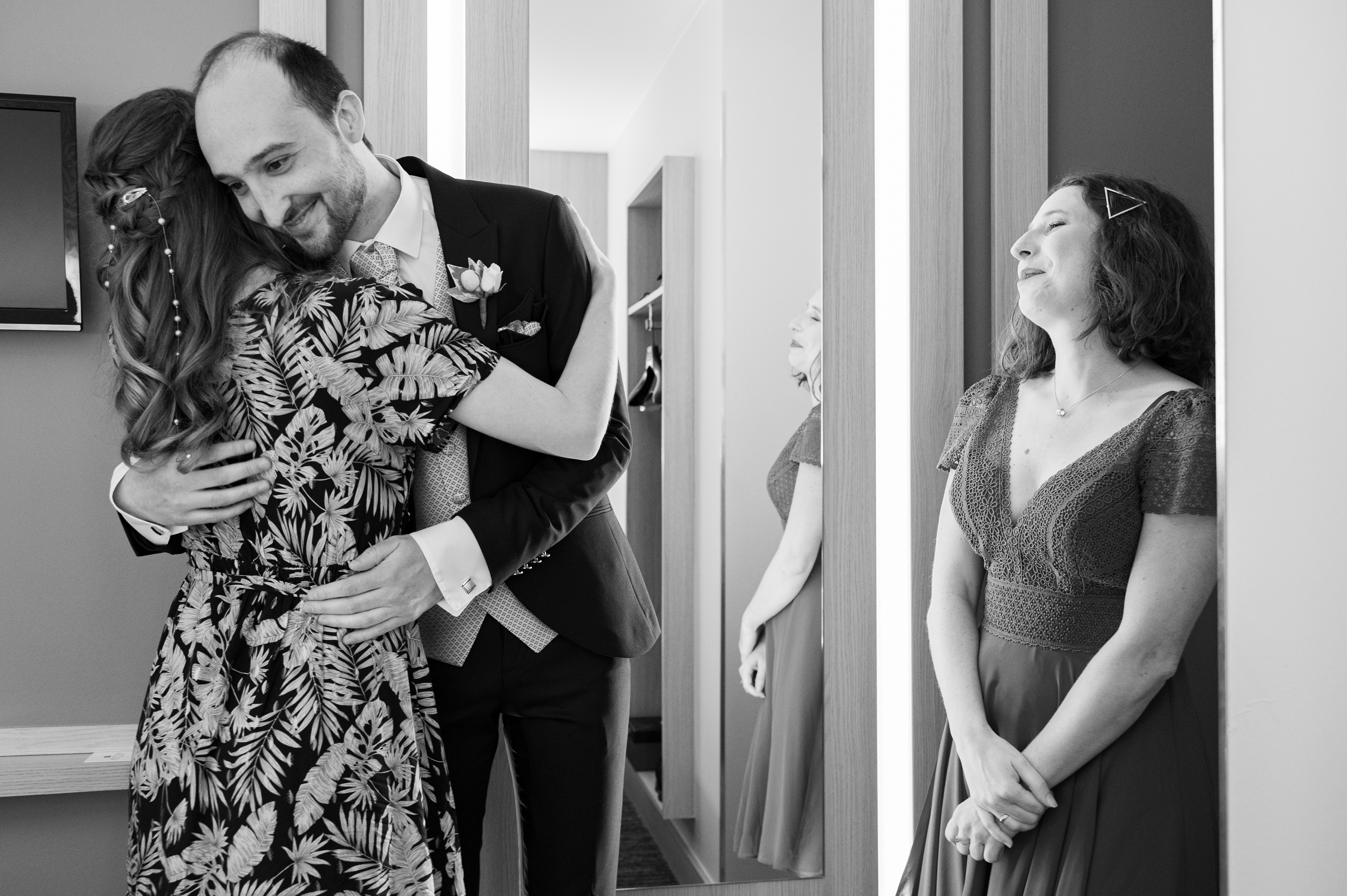 Un moment précieux entre le marié et la sœur de la mariée, sous l'œil attendri de sa témoin