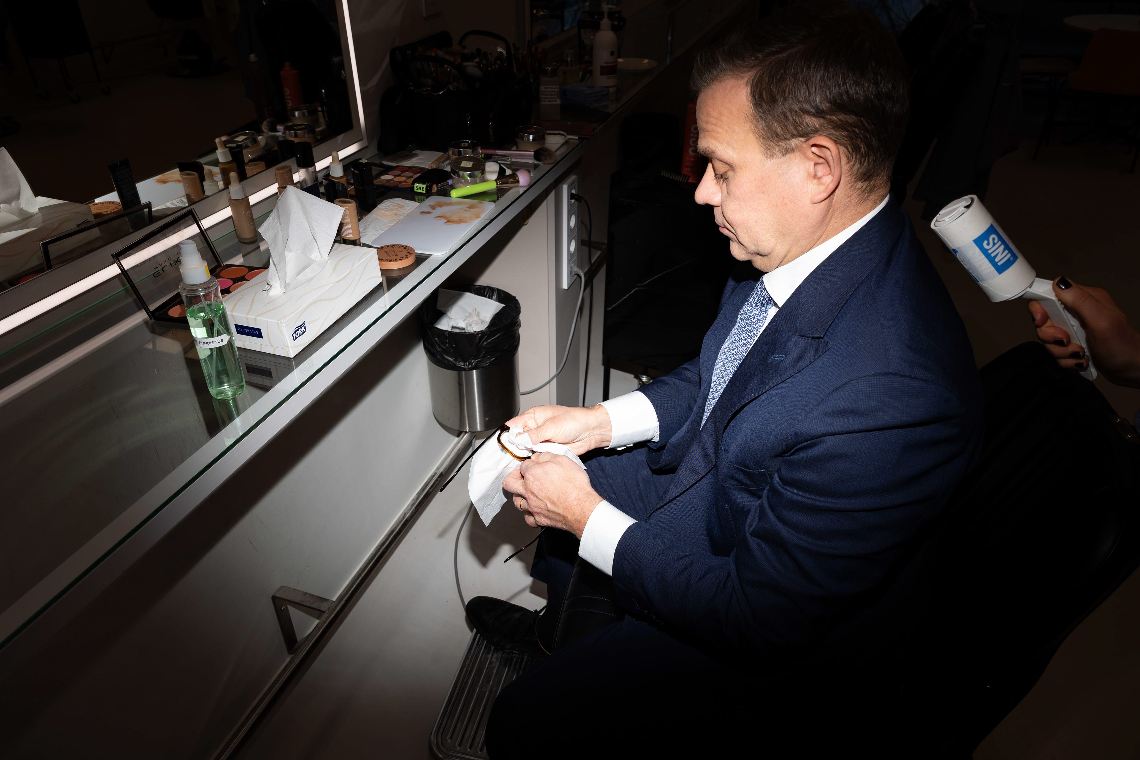 Prime Minister Petteri Orpo cleans his glasses before a tv interview by Yle, 2026.