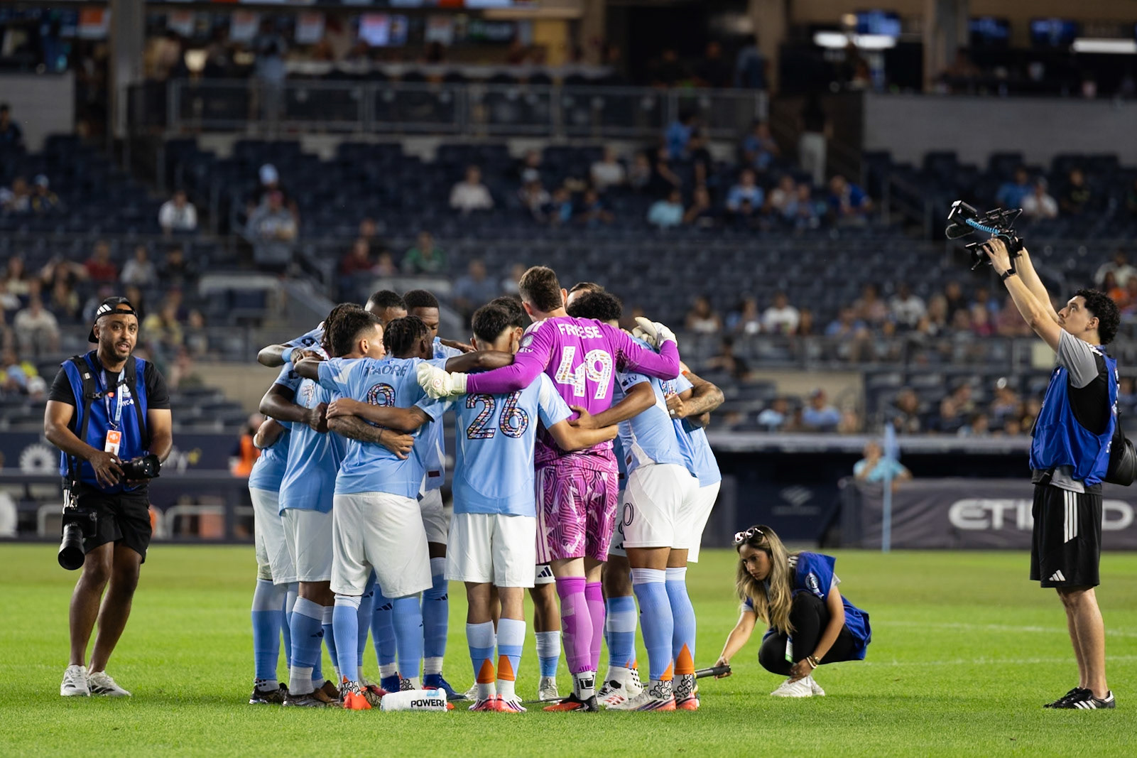 NYCFC players huddle before kickoff.