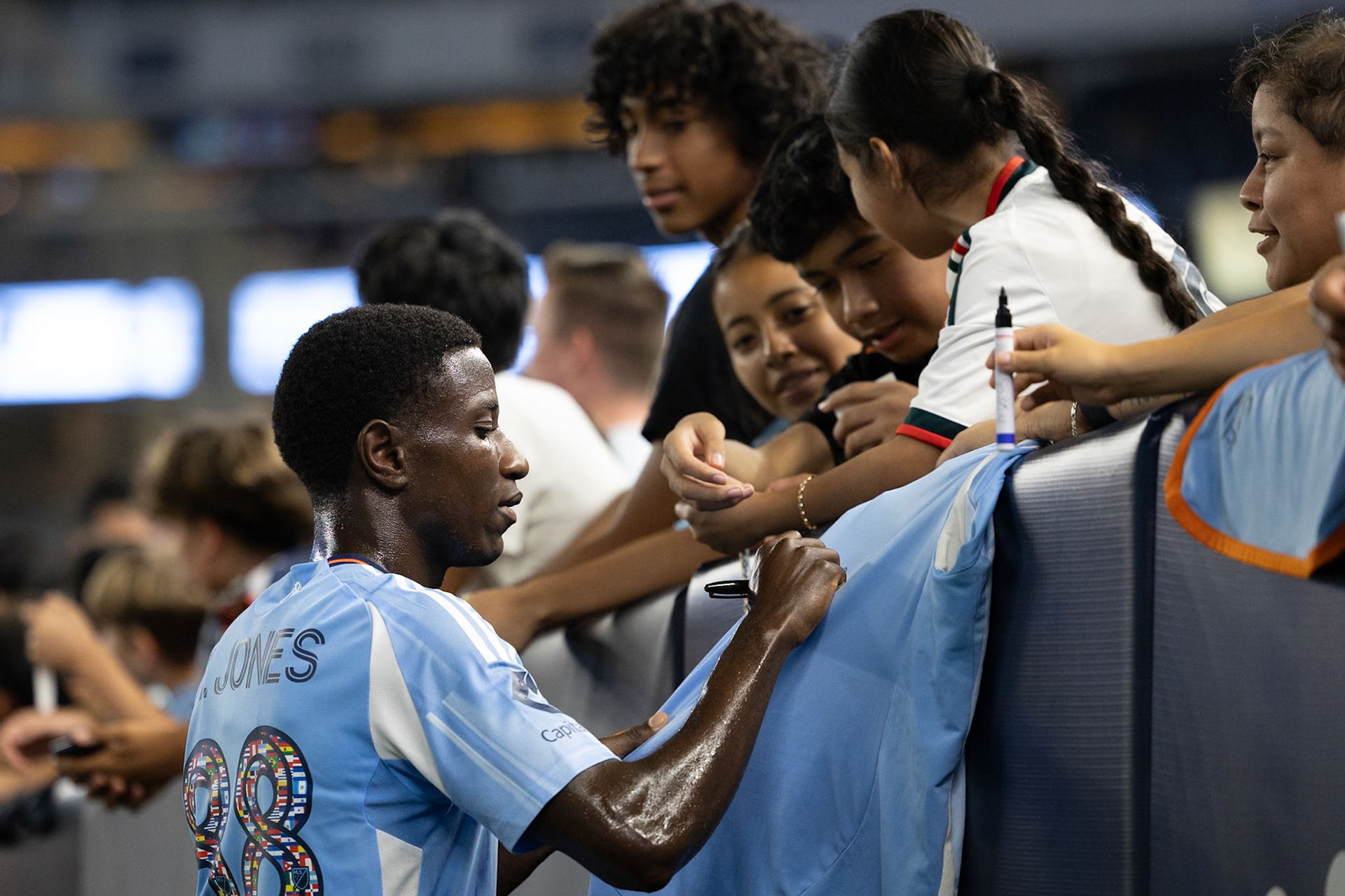 Malachi Jones (88) of New York City FC signs a fan’s jersey after the match against Nashville SC.