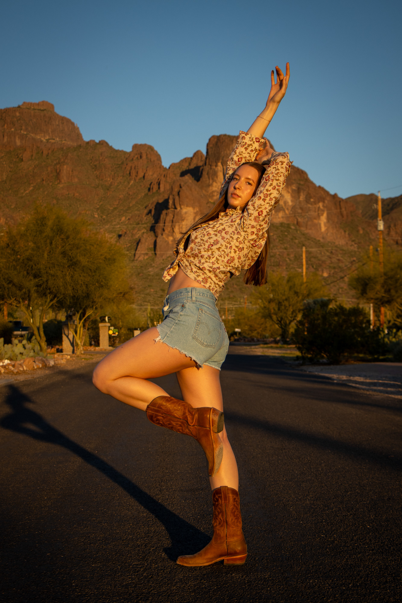 Woman striking a joyful dance pose looking directly into the camera