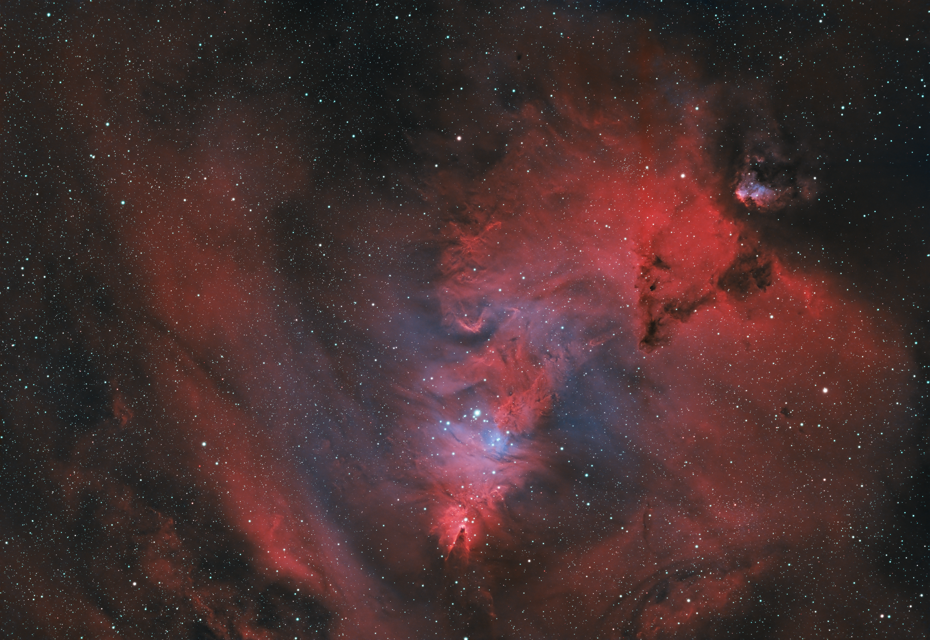 The Christmas Tree Nebula, part of the larger NGC 2264 region, is a festive and enchanting star-forming region located about 2,600 light-years away in the constellation Monoceros (the Unicorn). The nebula gets its name from the triangular arrangement of stars resembling a Christmas tree, with the bright star S Monocerotis marking the tree’s trunk. The Cone Nebula, a dark, conical cloud of gas and dust, forms the tree’s tip. This region is a dynamic stellar nursery, with young, hot stars illuminating surrounding hydrogen gas, causing it to glow with a reddish hue. The interplay of dark dust lanes and glowing gas creates a visually captivating cosmic landscape, evoking the magic of the holiday season.