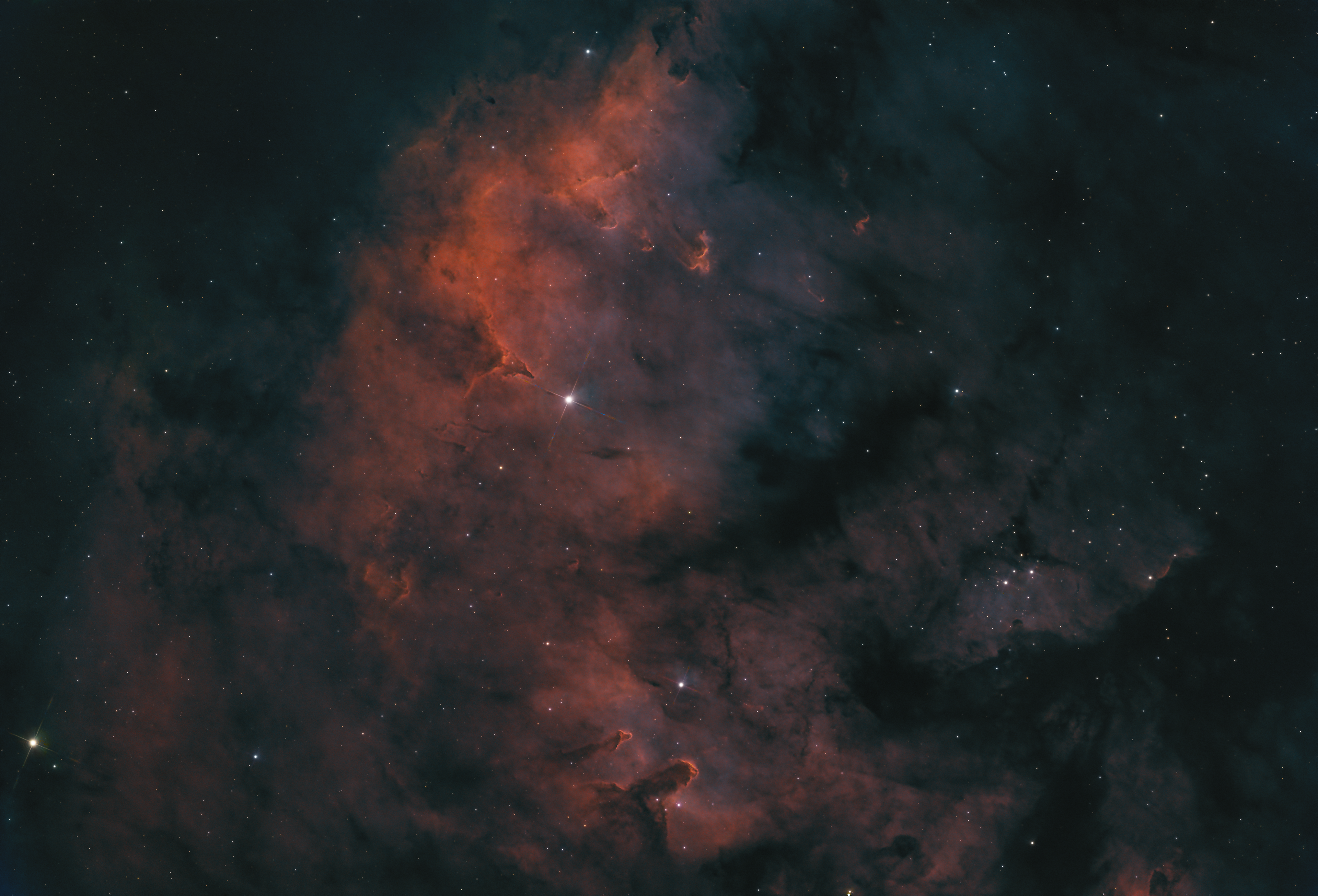 LDN 1272 is a dark nebula cataloged in Beverly T. Lynds’ Lynds’ Dark Nebulae Catalog. It is located in the constellation Cepheus, a region rich with interstellar dust and gas. Dark nebulae like LDN 1272 are dense clouds of gas and dust that block light from background stars and nebulae, appearing as dark, opaque patches against the luminous backdrop of the Milky Way. These nebulae often serve as stellar nurseries, where regions of higher density within the cloud can collapse under gravity to form new stars. LDN 1272, with its mysterious and obscured nature, offers a unique window into the early stages of star formation and the complex interactions within our galaxy’s interstellar medium.