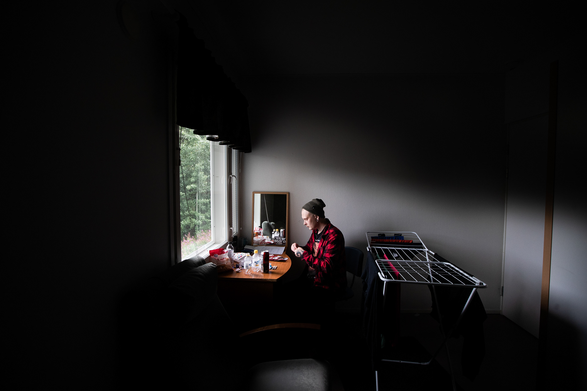 Mika käärii rivin sätkiä omassa huoneessaan.