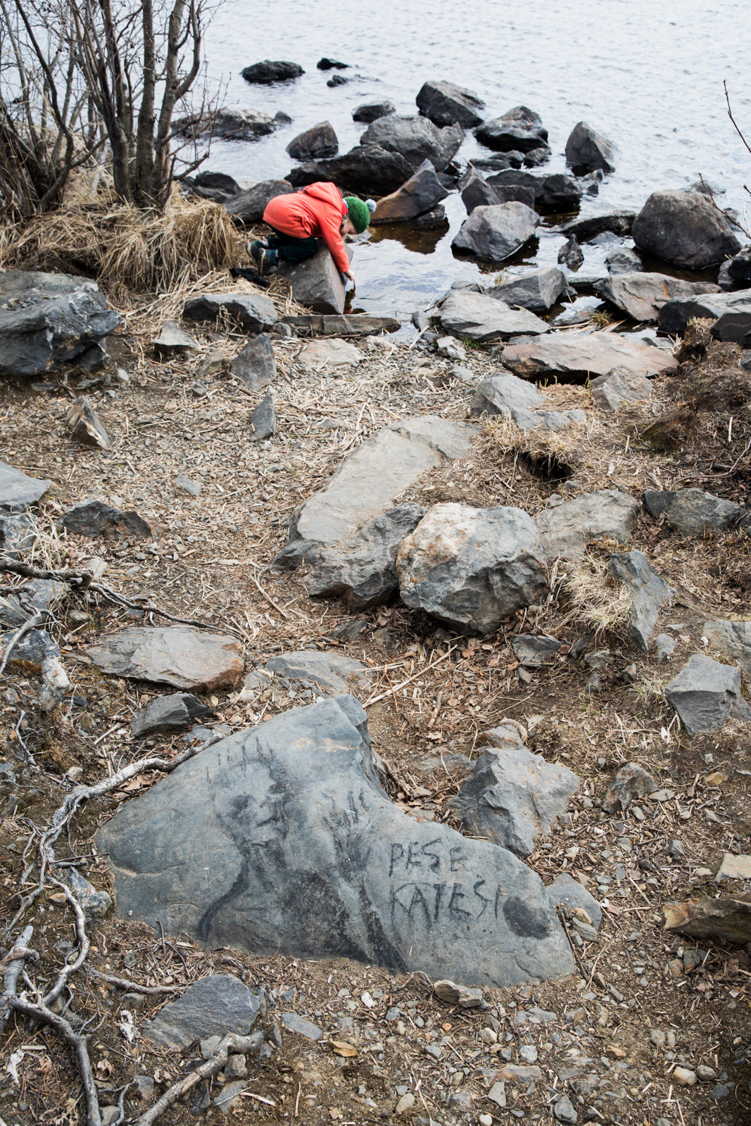 Joku oli polttanut läheisellä rannalla nuotiota ja piirtänyt hiilellä kiveen. On ihanaa keikkua kivillä ja etsiä vedestä aarretta. Kädet peseytyy siinä samalla. 