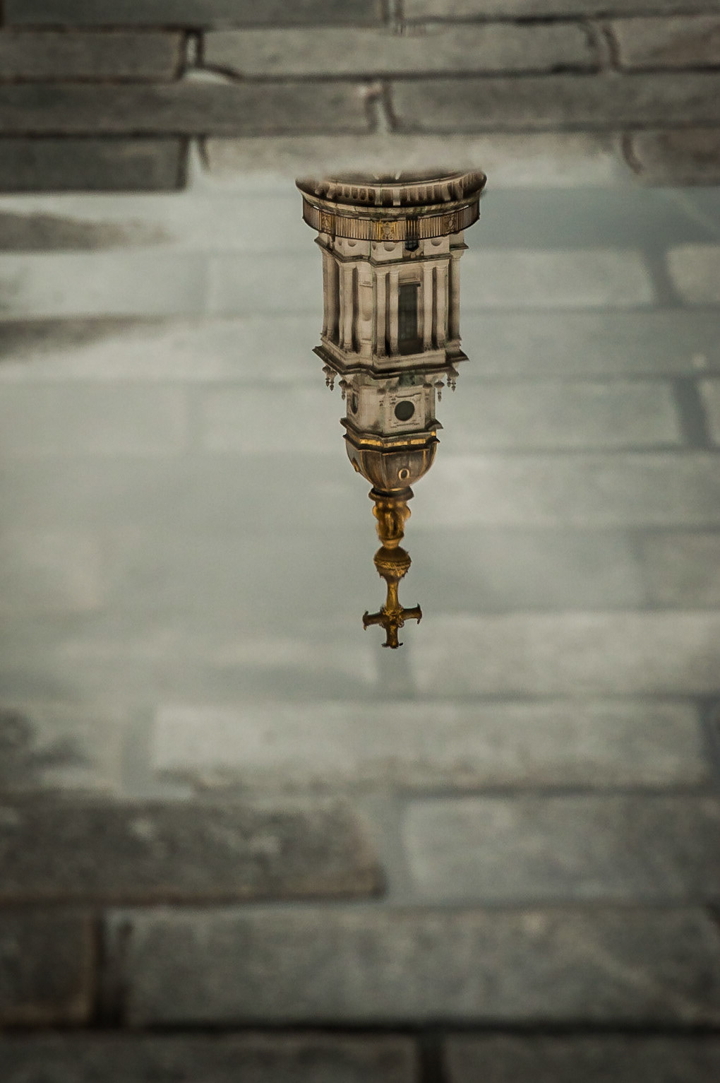 Easily London's most iconic landmark. St Pauls Cathedral. I thought I had photographed the amazing dome of St Pauls from every angle, until I found this fantastic old side street leading to its western approach. My Nikon 80-400mm lens helped cut out the shop signs and people and focus on the beauty of London's finest historical architecture. The rain had just stopped and left numerous puddles of water in these beautiful cobbled streets. Everyone was too busy texting on their iphones to notice the beautiful reflections of the perfect top of St Pauls Cathedral. I received some strange looks as most people couldn't even notice what I was photographing!