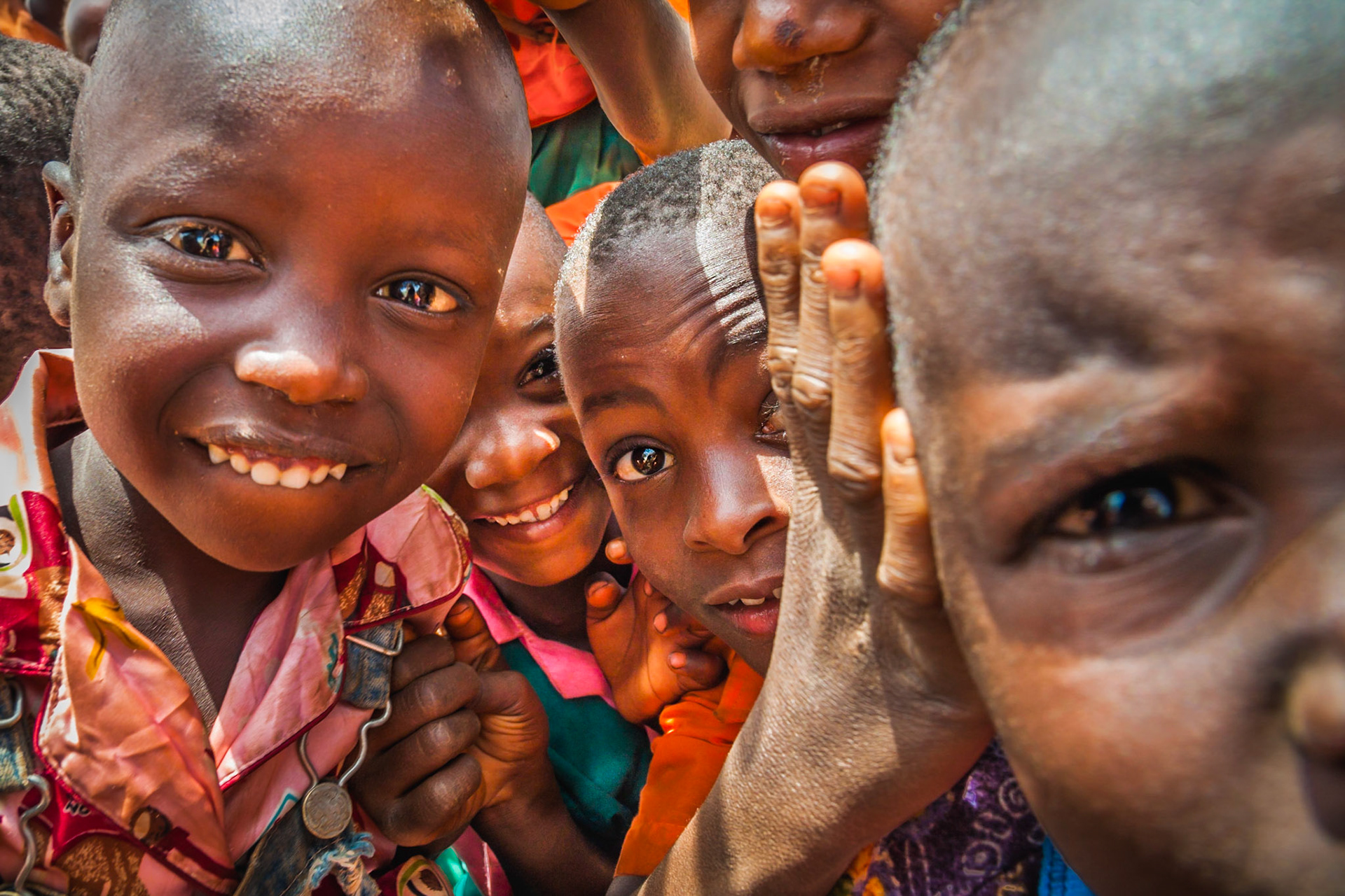 Lunchtime was always chaotic on the building site, as all of the children would race out of their classroom to come see the white people building their new school. These are the amazing kids from Tankini villages and school. Not all of them have school uniform for now, but the ones who do wear this incredible bright orange which just gives the images such a punch! Most of these shots were taken whilst being mobbed and surrounded by the entire class all trying to star in their own portrait… at the same time.