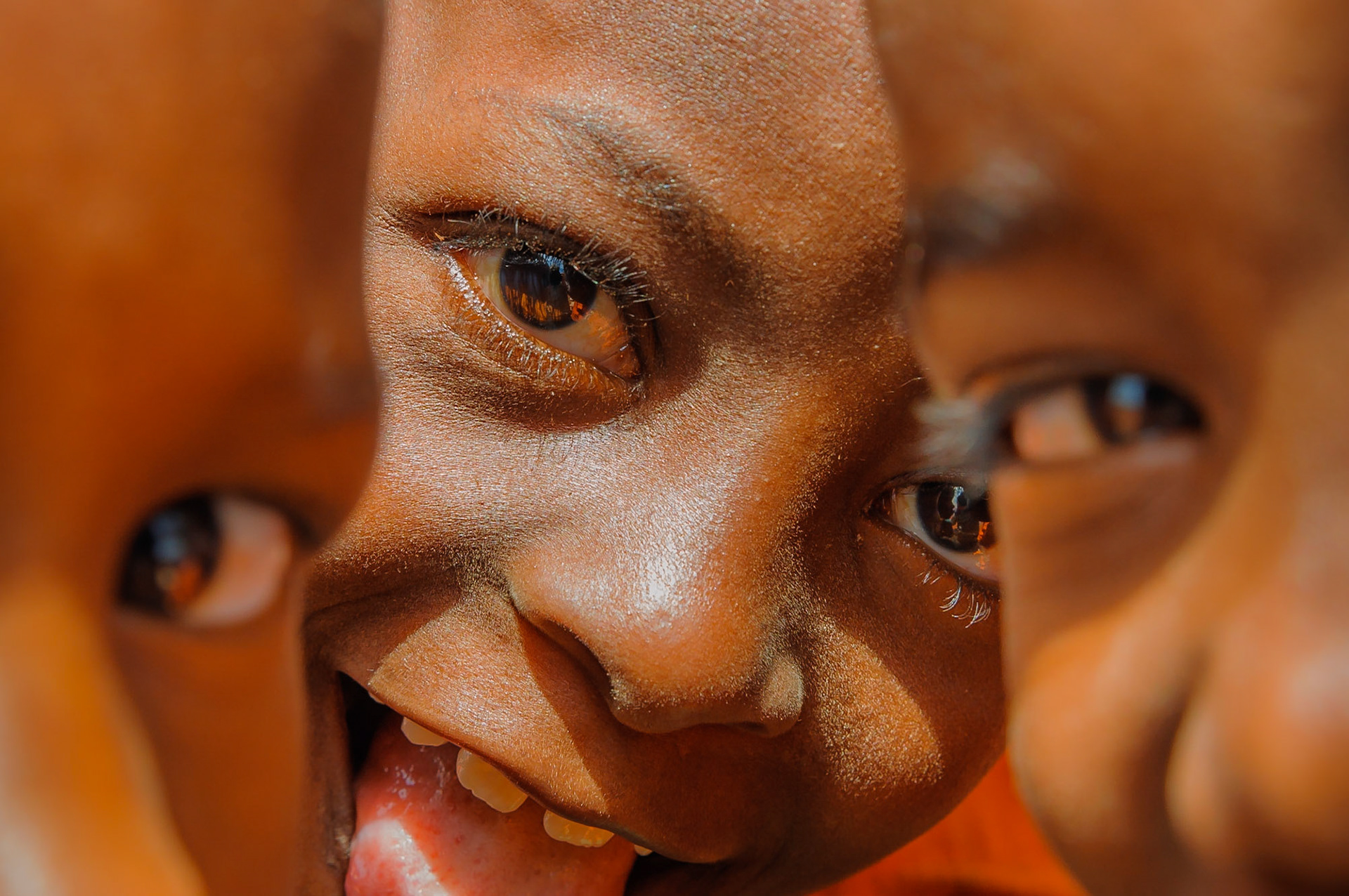 Lunchtime was always chaotic on the building site, as all of the children would race out of their classroom to come see the white people building their new school. These are the amazing kids from Tankini villages and school. Not all of them have school uniform for now, but the ones who do wear this incredible bright orange which just gives the images such a punch! Most of these shots were taken whilst being mobbed and surrounded by the entire class all trying to star in their own portrait… at the same time.
