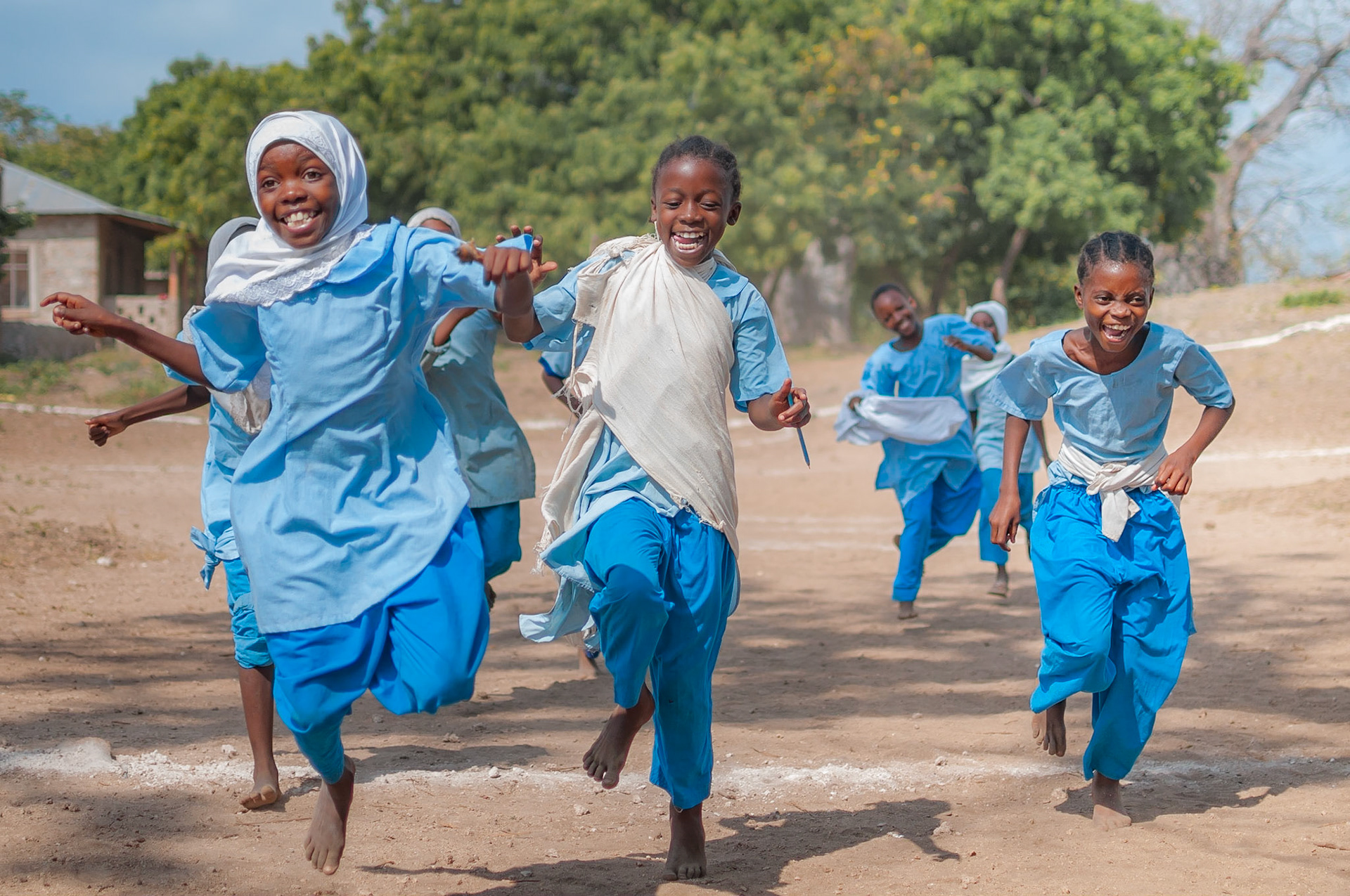 The girls sports class at Mkwiro Primary School plays relay races with the GVI Volunteers on the playground.