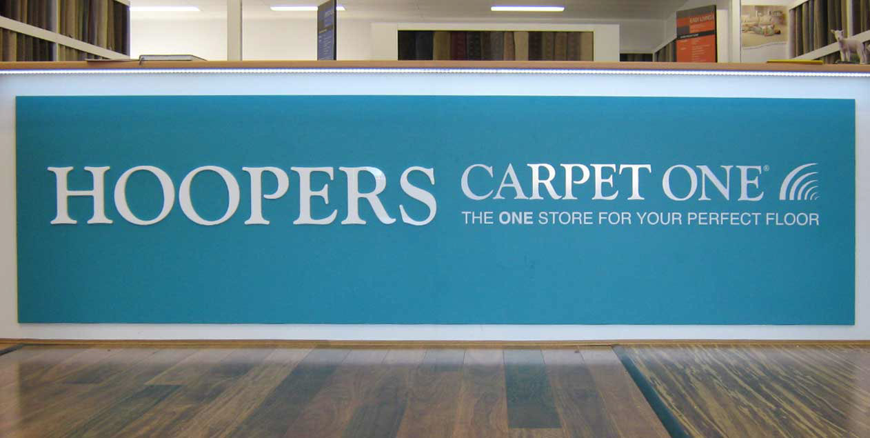 Hoopers Carpet One customer service desk with acrylic and vinyl lettering