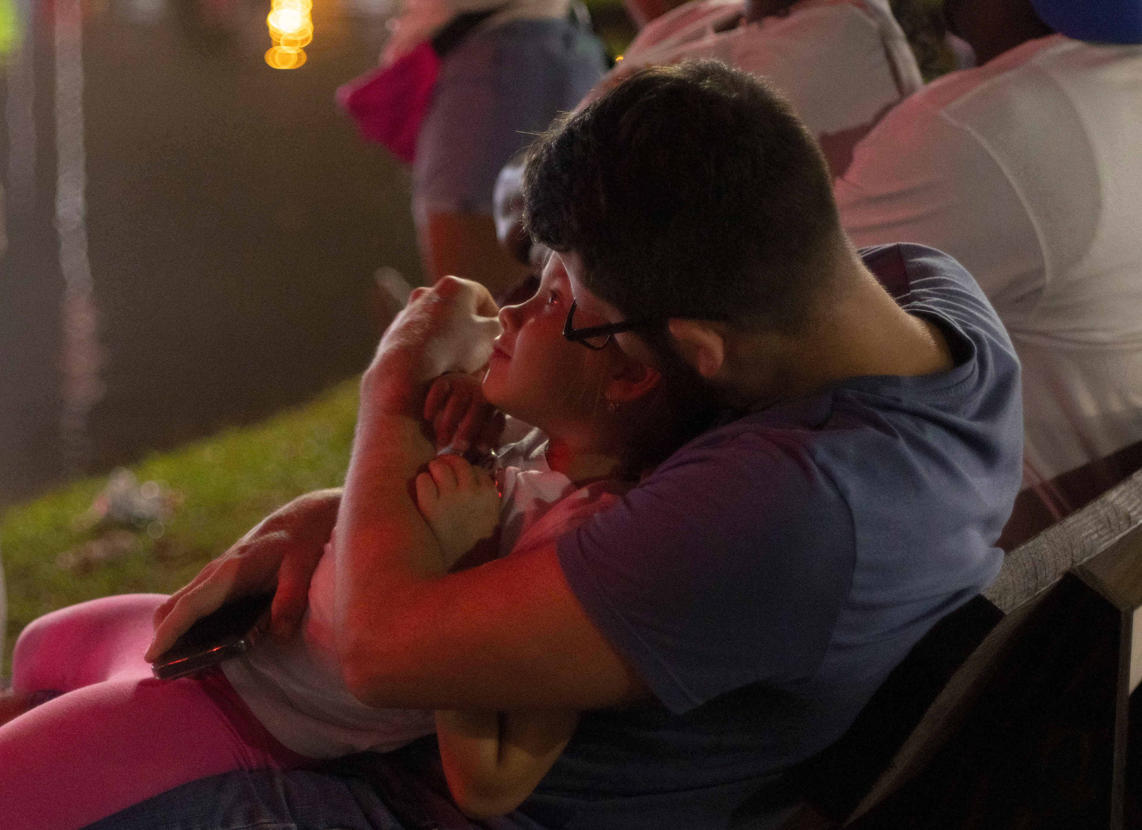 Mira Nikolayeva, 6, watches an evening firework show in the arms of her father, Ilya Nikolayeva, at the Georgia National Fairgrounds and Agriculture Center on Oct. 5, 2024. 