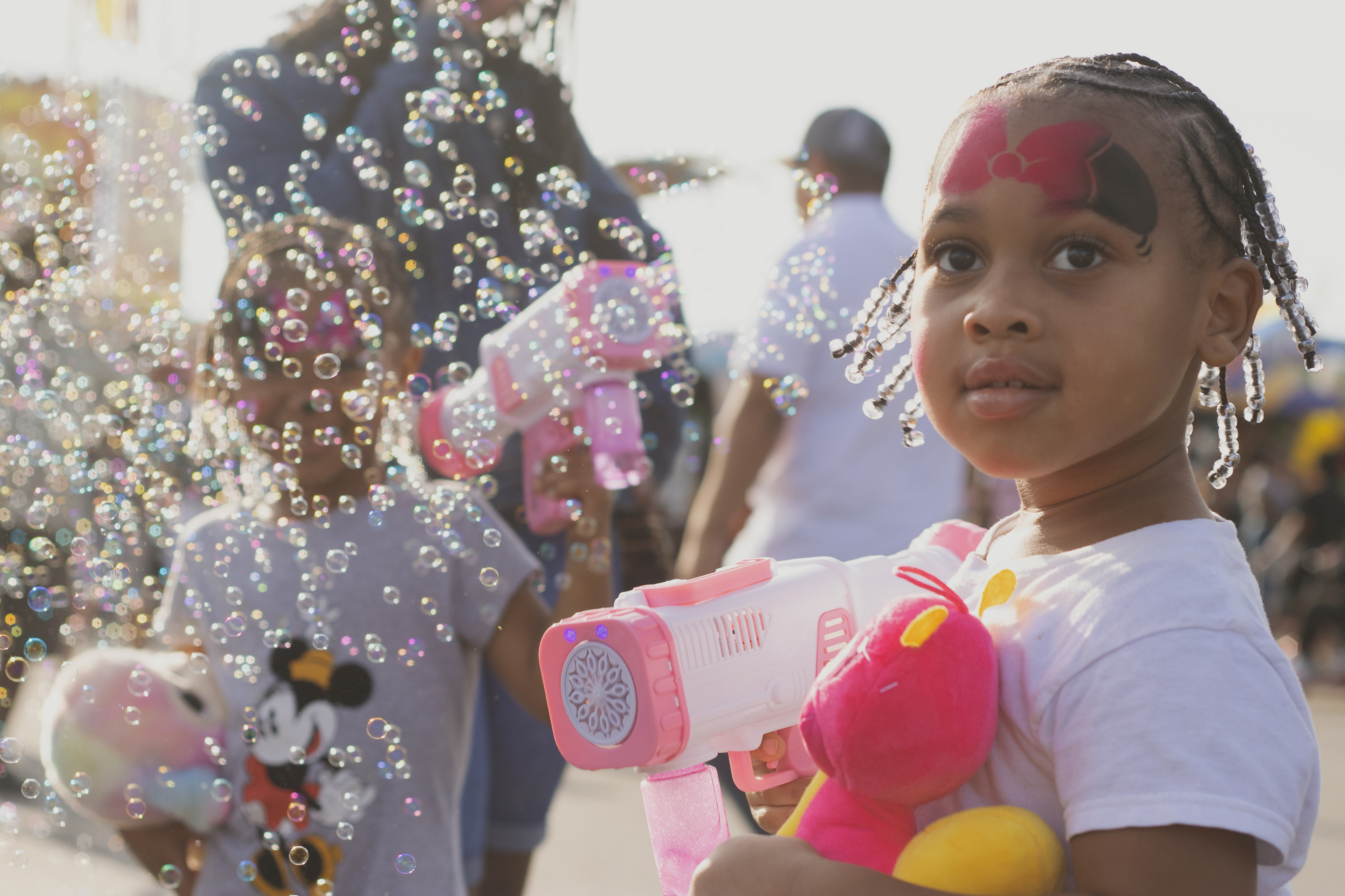 Brayleigh Campbell, 3, blows bubbles with a bubble machine alongside her sister Sevyn, 4, at the Georgia National Fairgrounds and Agriculture Center on Oct. 5, 2024. This year marks their first time attending the fair.