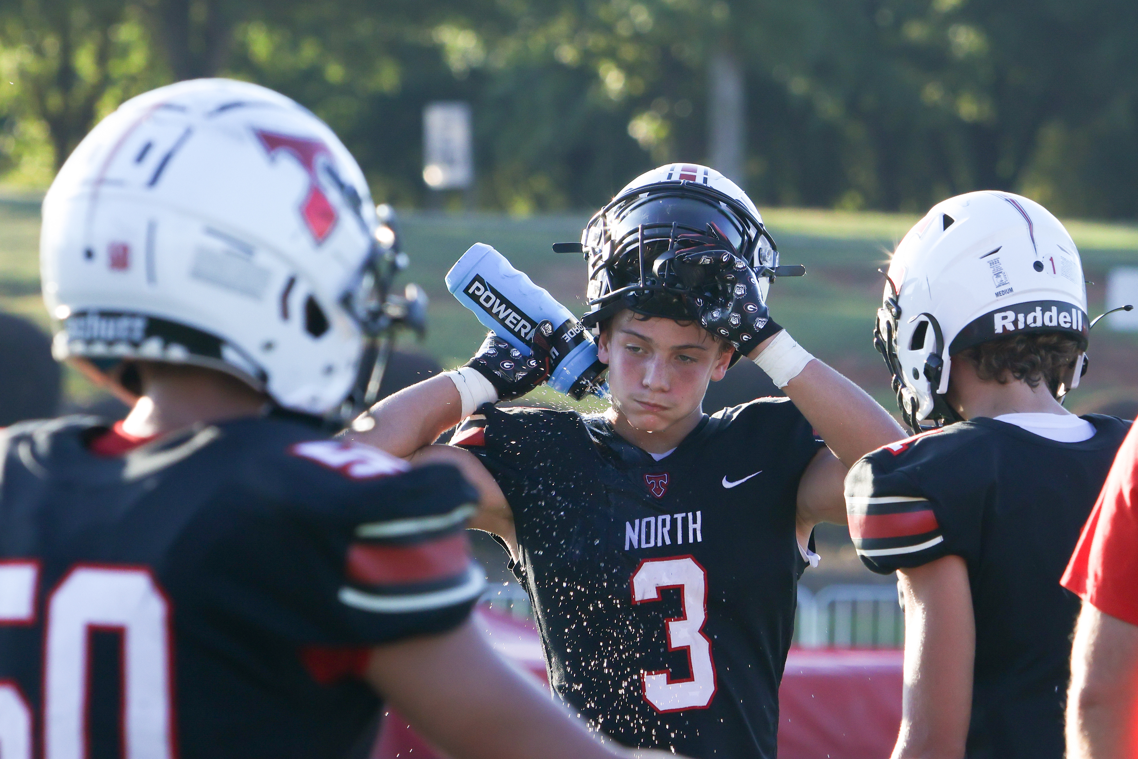 North Oconee high school wide receiver and defensive back Jackson Fisher cools himself off during a mid-game time out at North Oconee high school on Sept. 25, 2024.