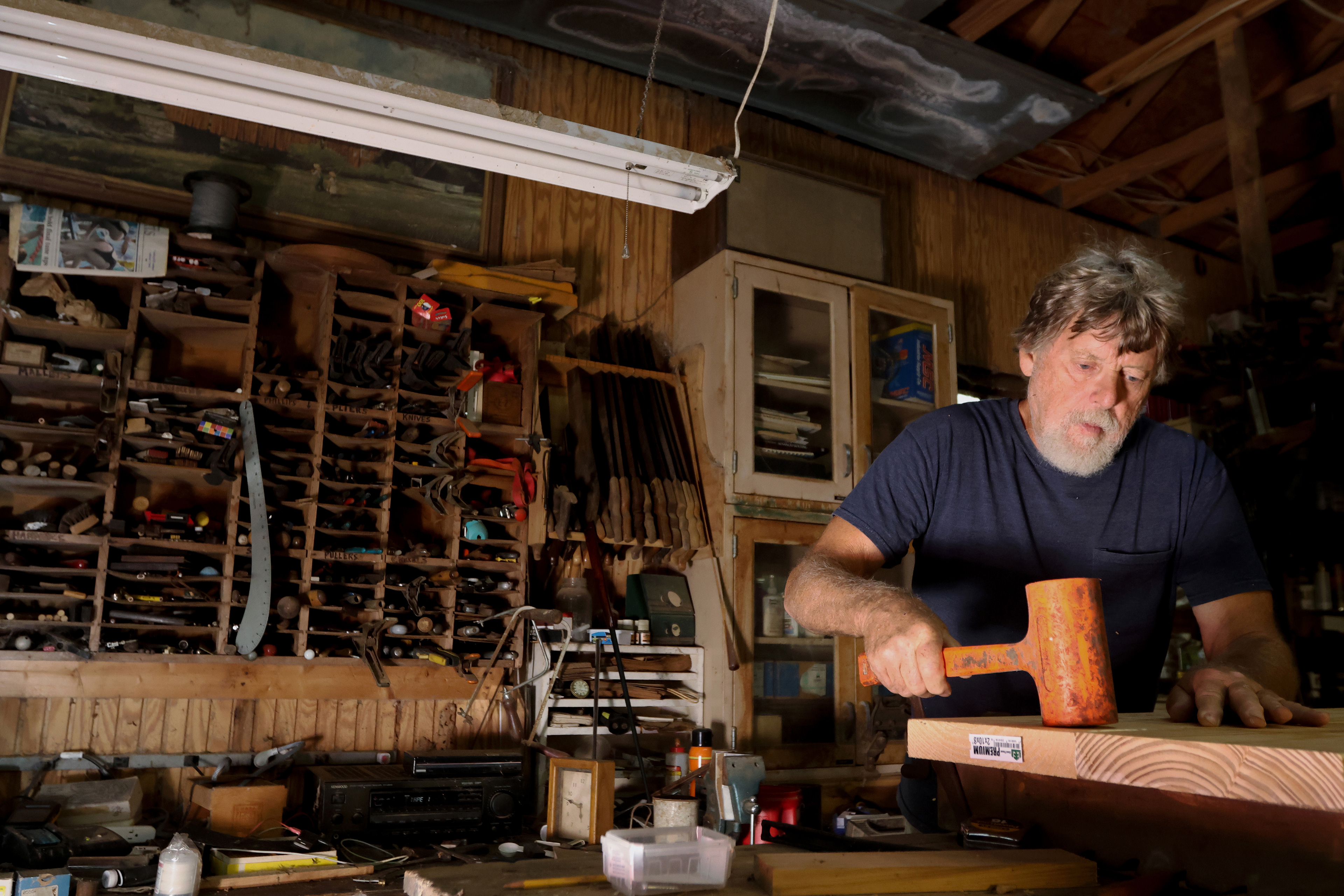 Lee Moody, self-taught builder and woodworker based in Good Hope, Georgia, glues joined boards together to make a table top on Sept. 3, 2024. Moody specialized in furniture restoration in the 1980's, and now primarily does mechanical and wood repairs for the farm he owns.