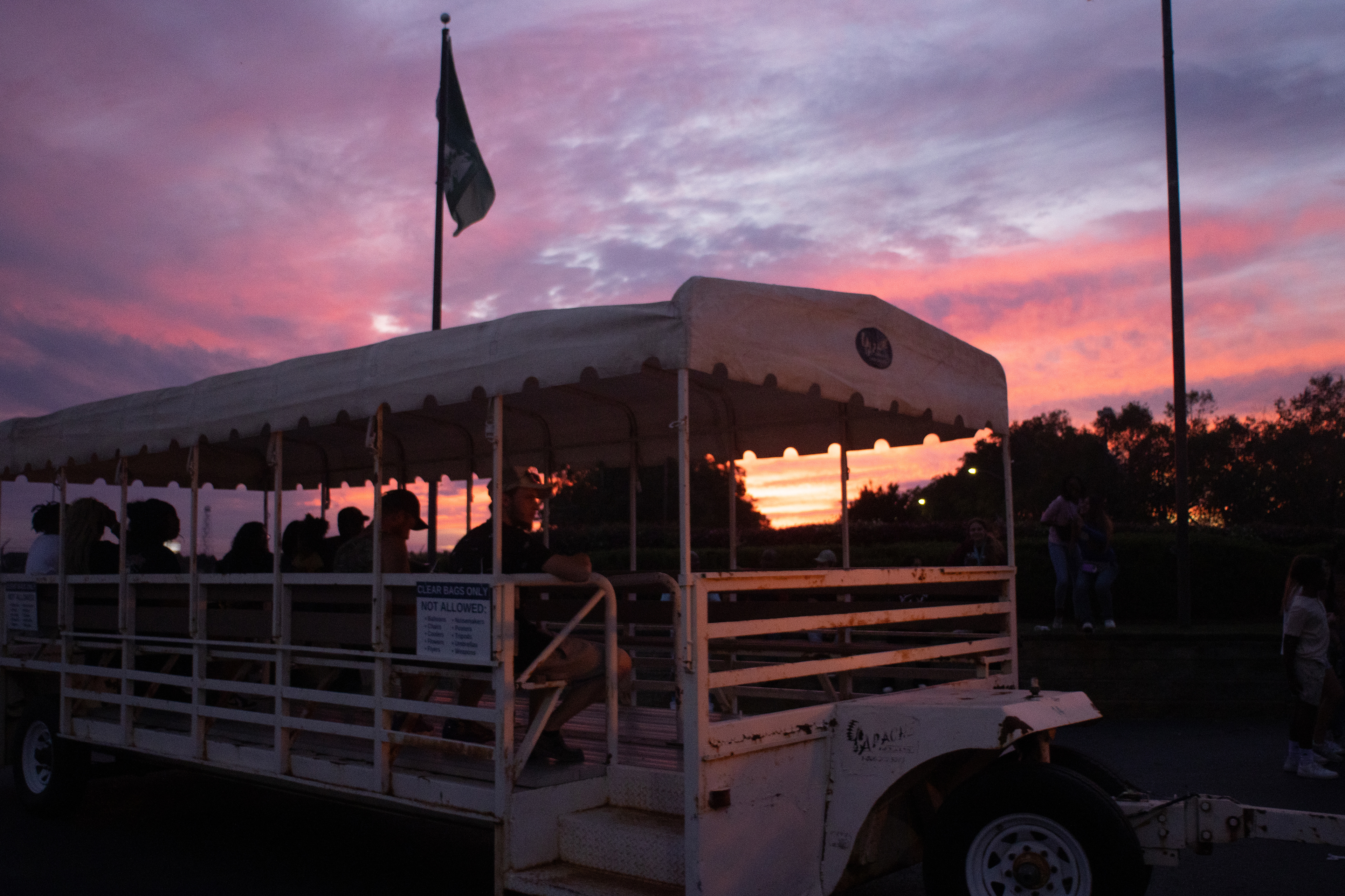 Fairgoers ride a trolley pulled by a tractor that takes them back to their cars at the Georgia National Fairgrounds and Agriculture Center on Oct. 5, 2024.